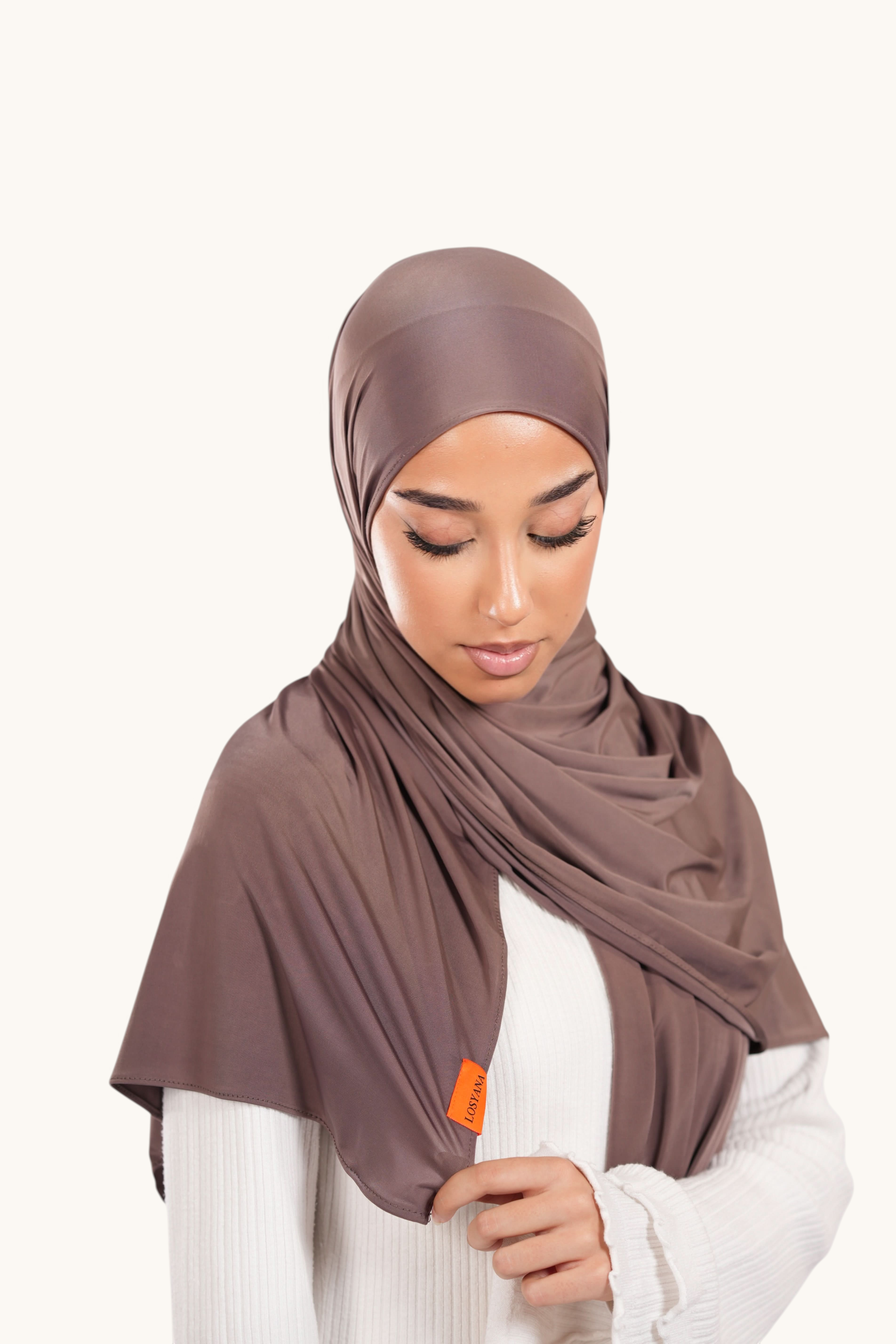 Model wearing a coffee brown LOSYANA Liquid Jersey hijab with a subtle sheen and branded orange tag