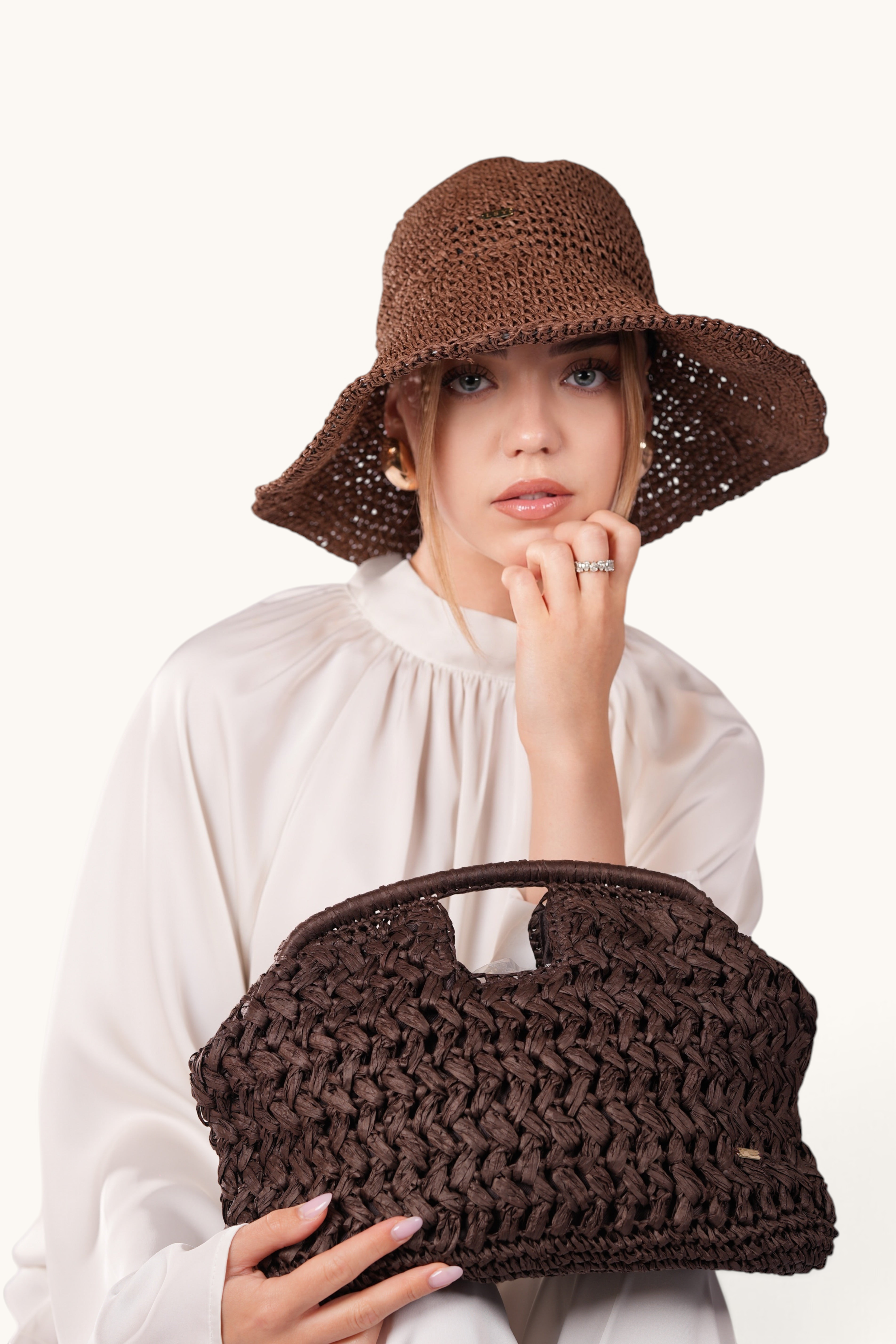 LOSYANA LSY woven straw handbag in espresso brown held by a model wearing a matching straw hat