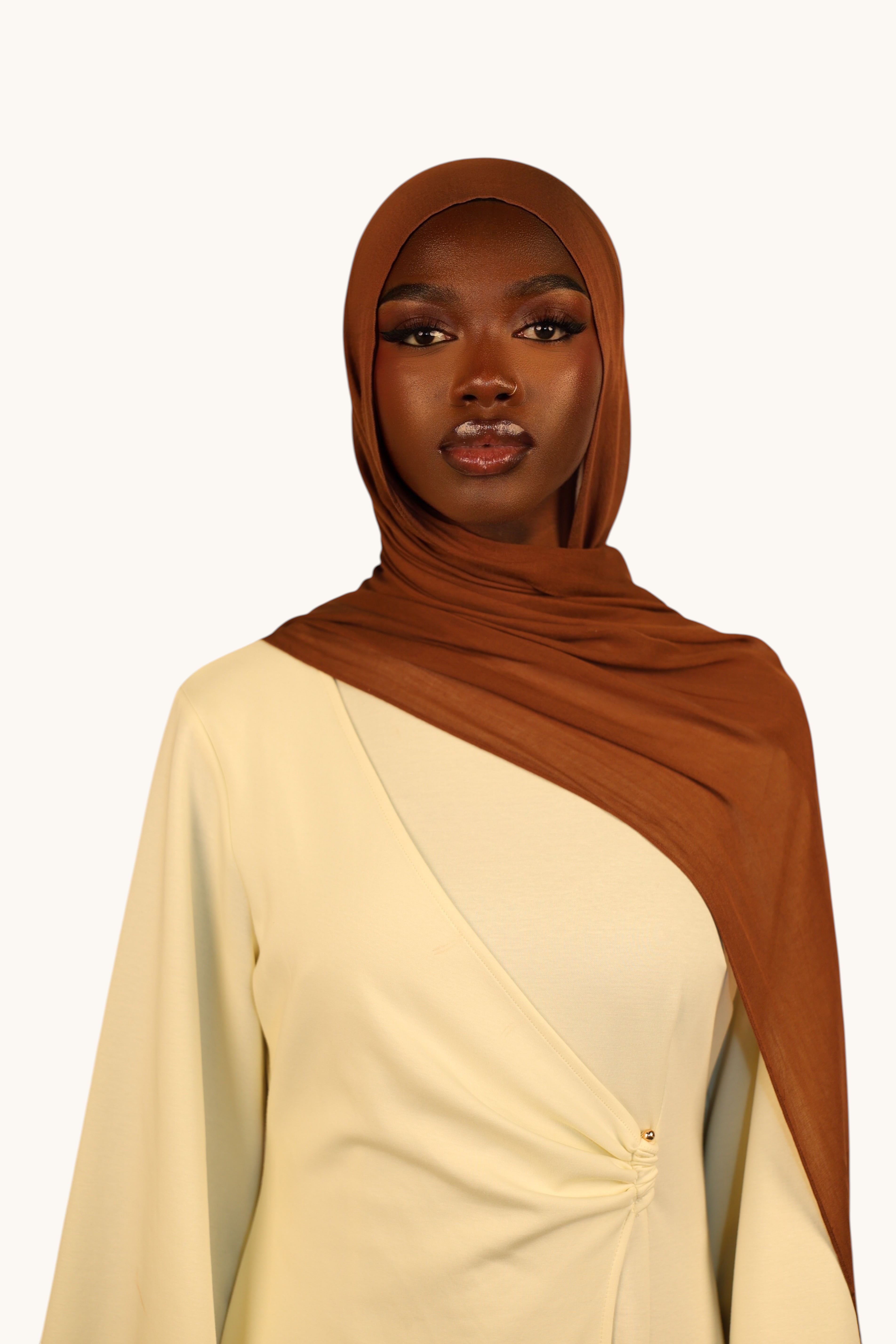LOSYANA lightweight maroon modal hijab worn by a model in a cream-colored wrap top, elegant and flowing fabric.