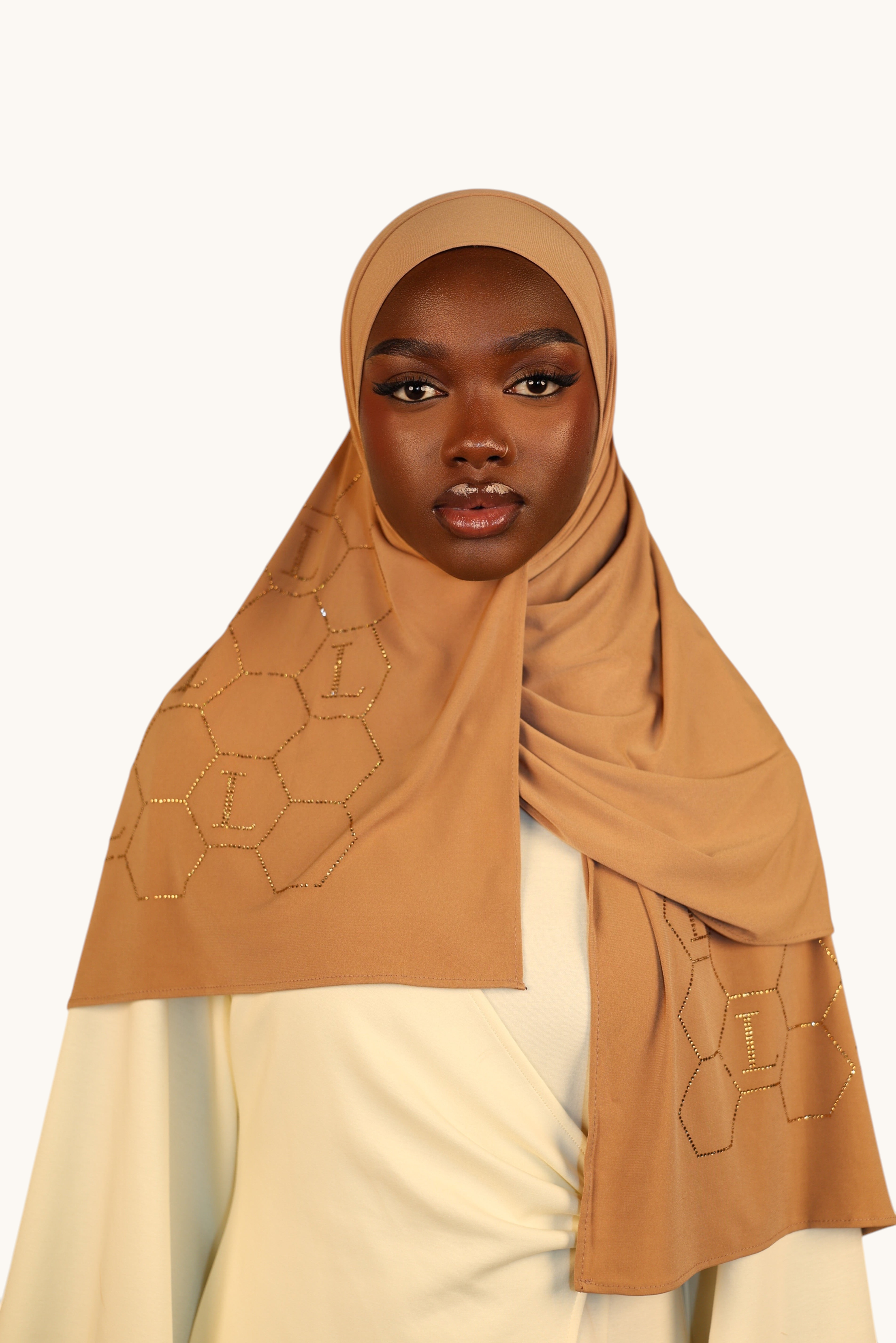 LOSYANA mustard premium jersey hijab featuring elegant gold rhinestone L-pattern detailing worn by a model