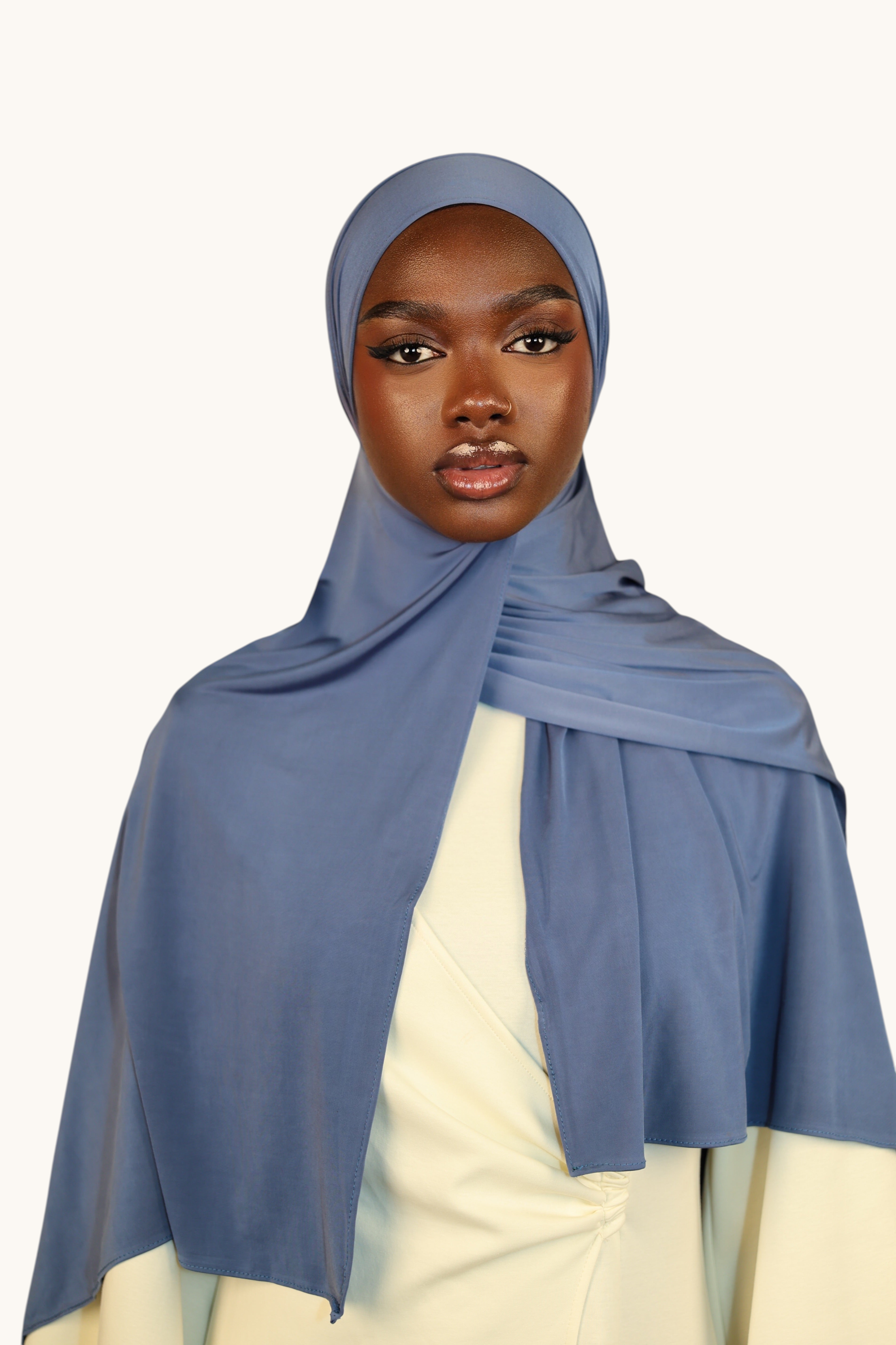 Model wearing a LOSYANA ocean blue liquid jersey hijab with a subtle satin sheen, styled elegantly.