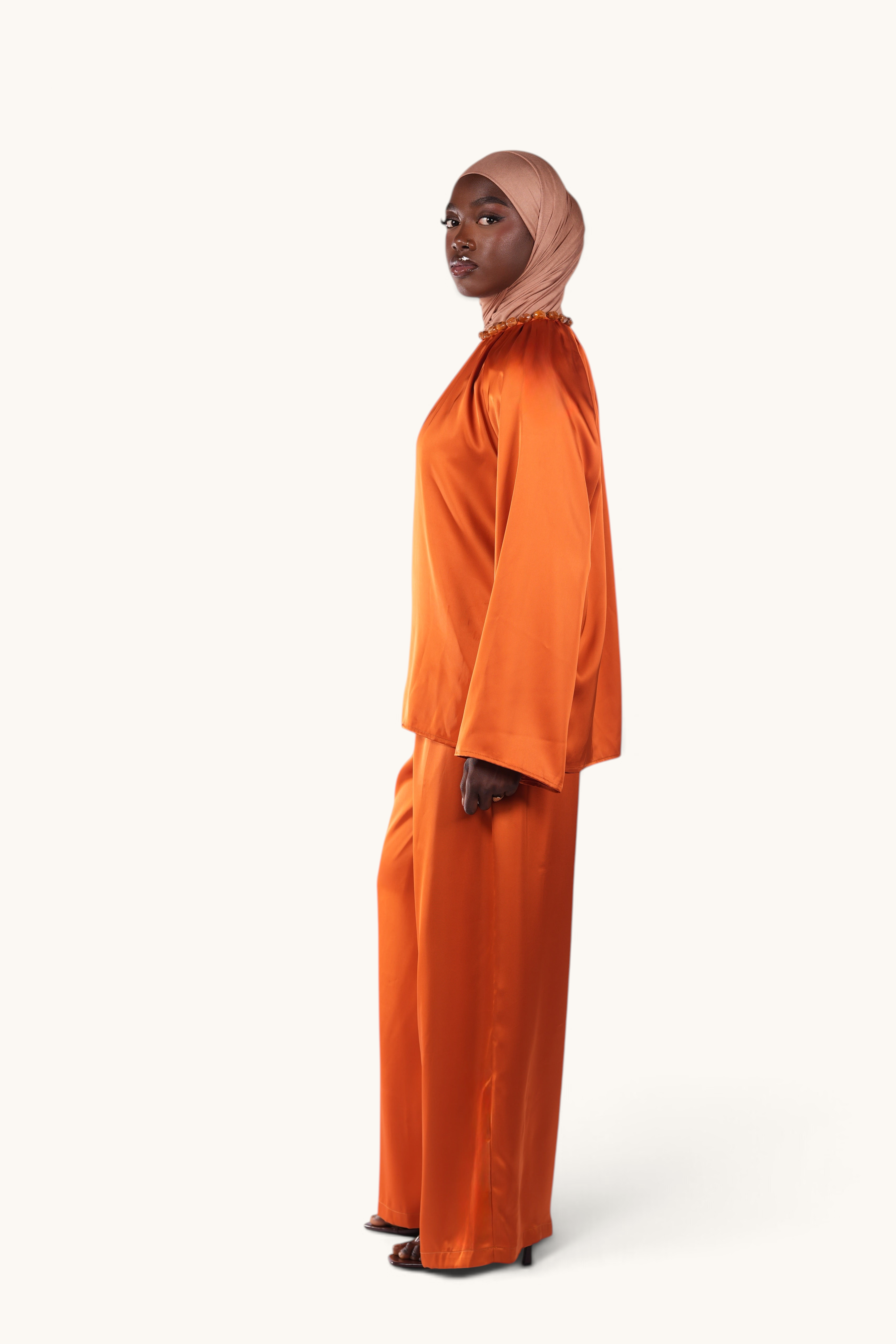 LOSYANA La Marina papaya satin two-piece set with acrylic stone collar worn by a model in a hijab
