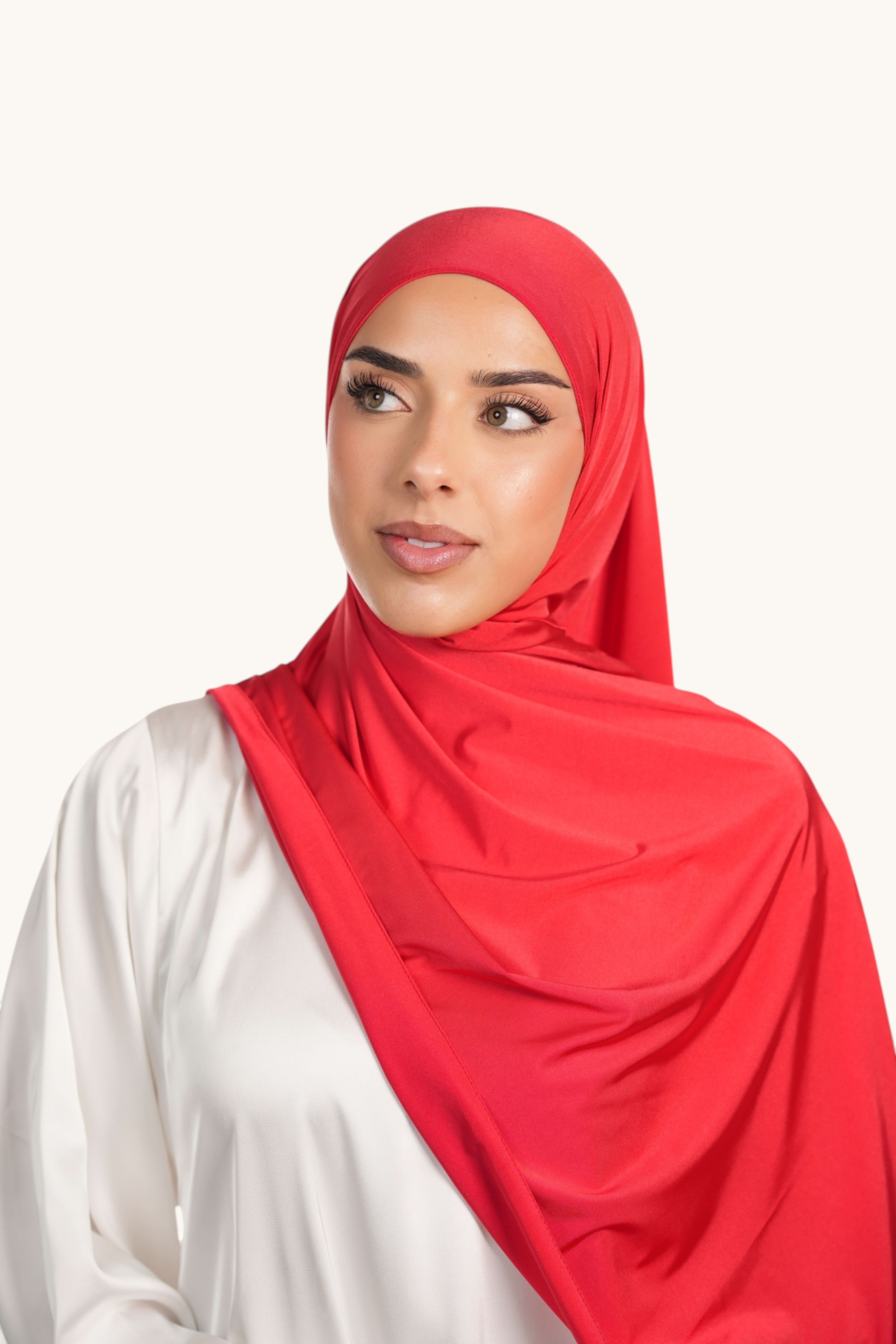 Model wearing a vibrant red LOSYANA satin jersey hijab, featuring a non-slip, opaque fabric with elegant draping.