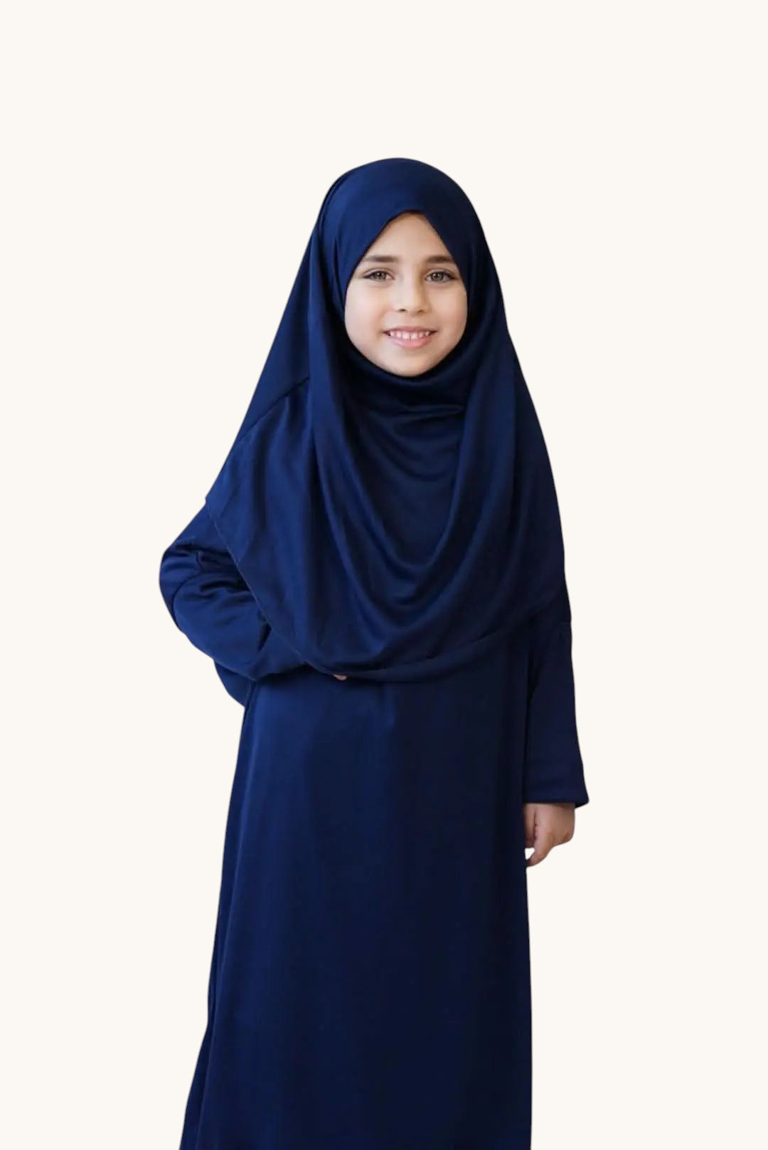 Young girl wearing a royal blue LOSYANA jersey prayer dress with an integrated hijab for comfortable daily prayer.