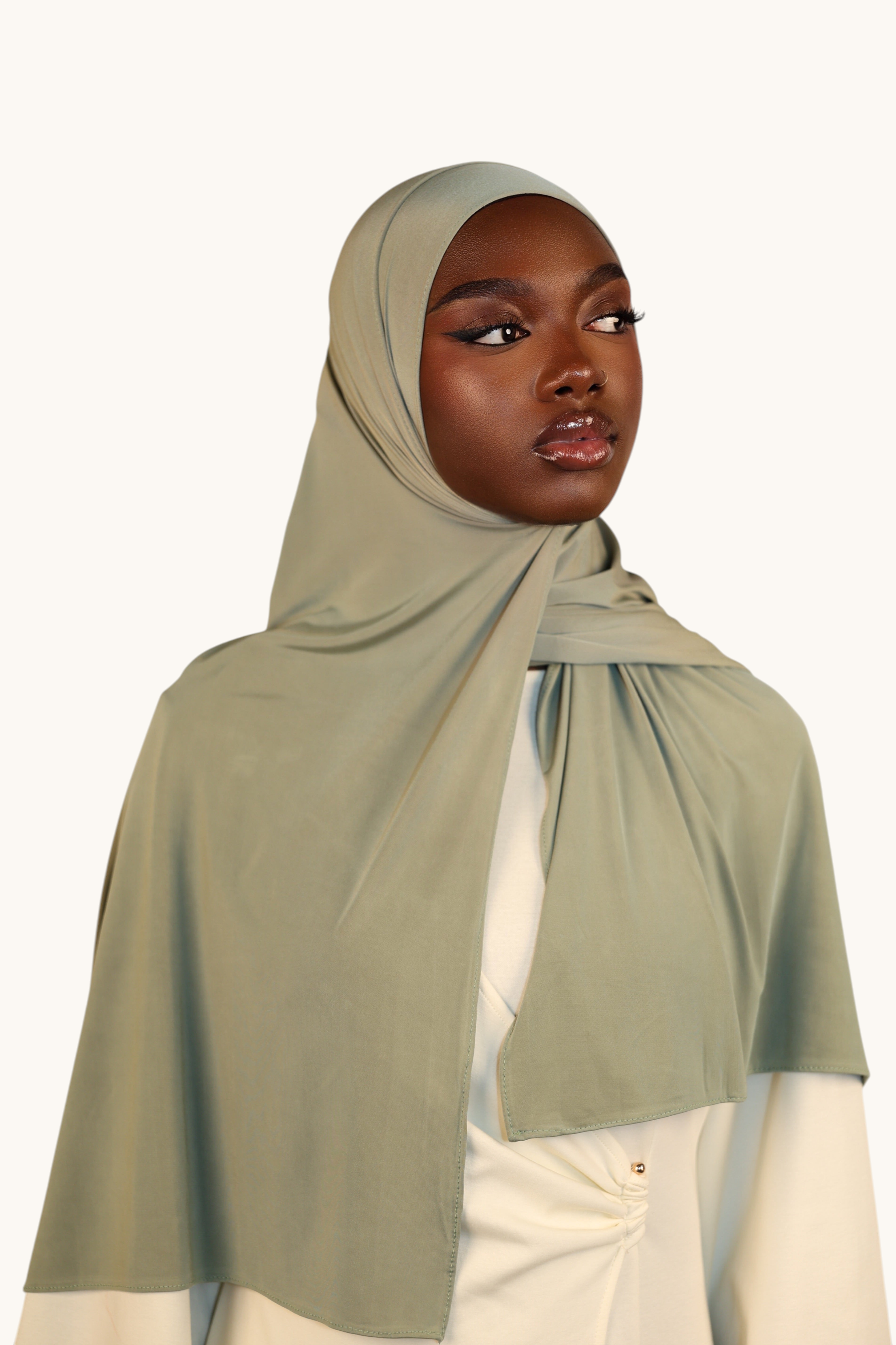 LOSYANA sage green liquid jersey hijab worn by a model, featuring a lightweight, elegant, and soft fabric finish.