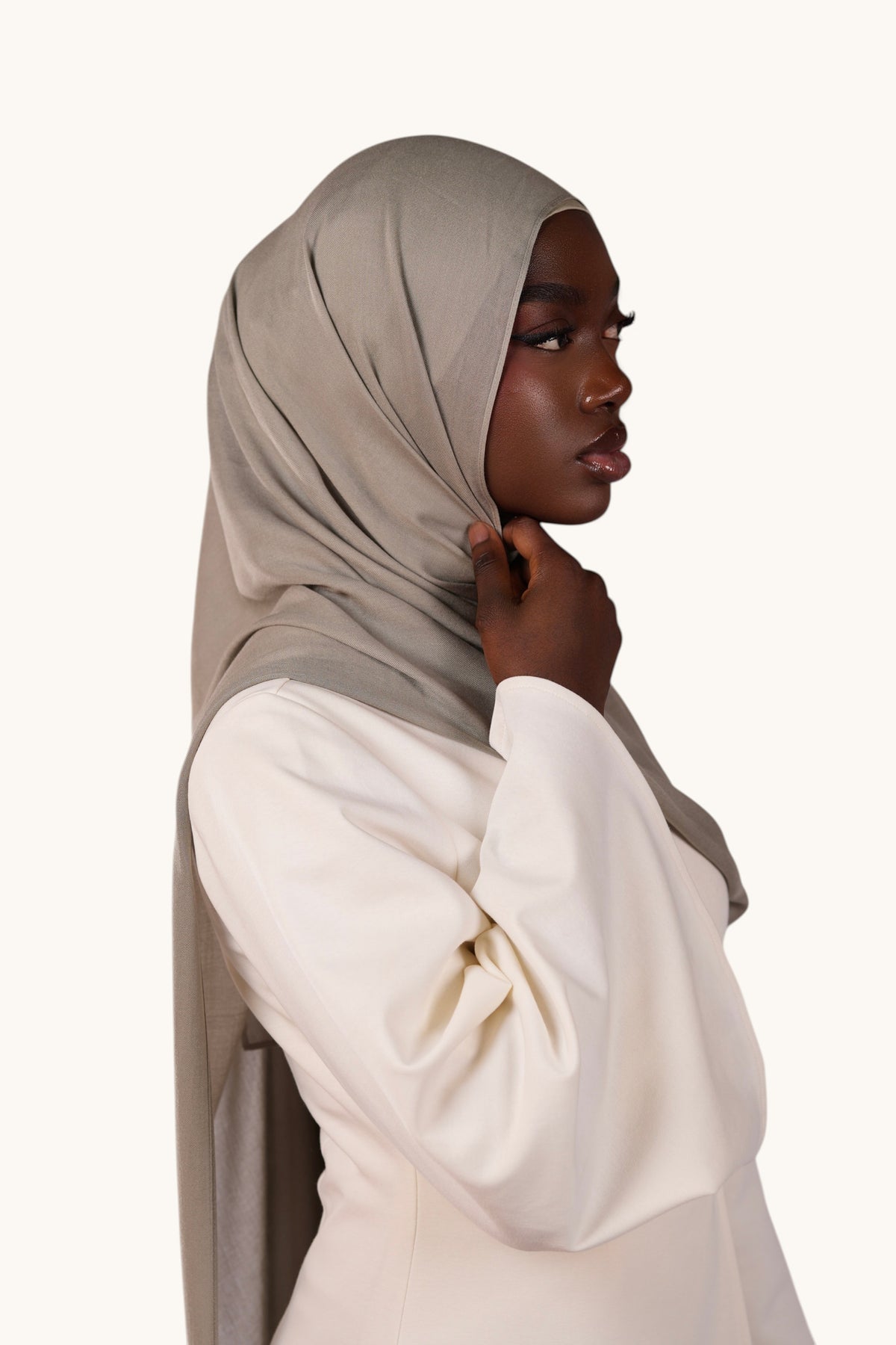 Model wearing a lightweight sage green LOSYANA modal hijab with a flowing, elegant drape against a white background.