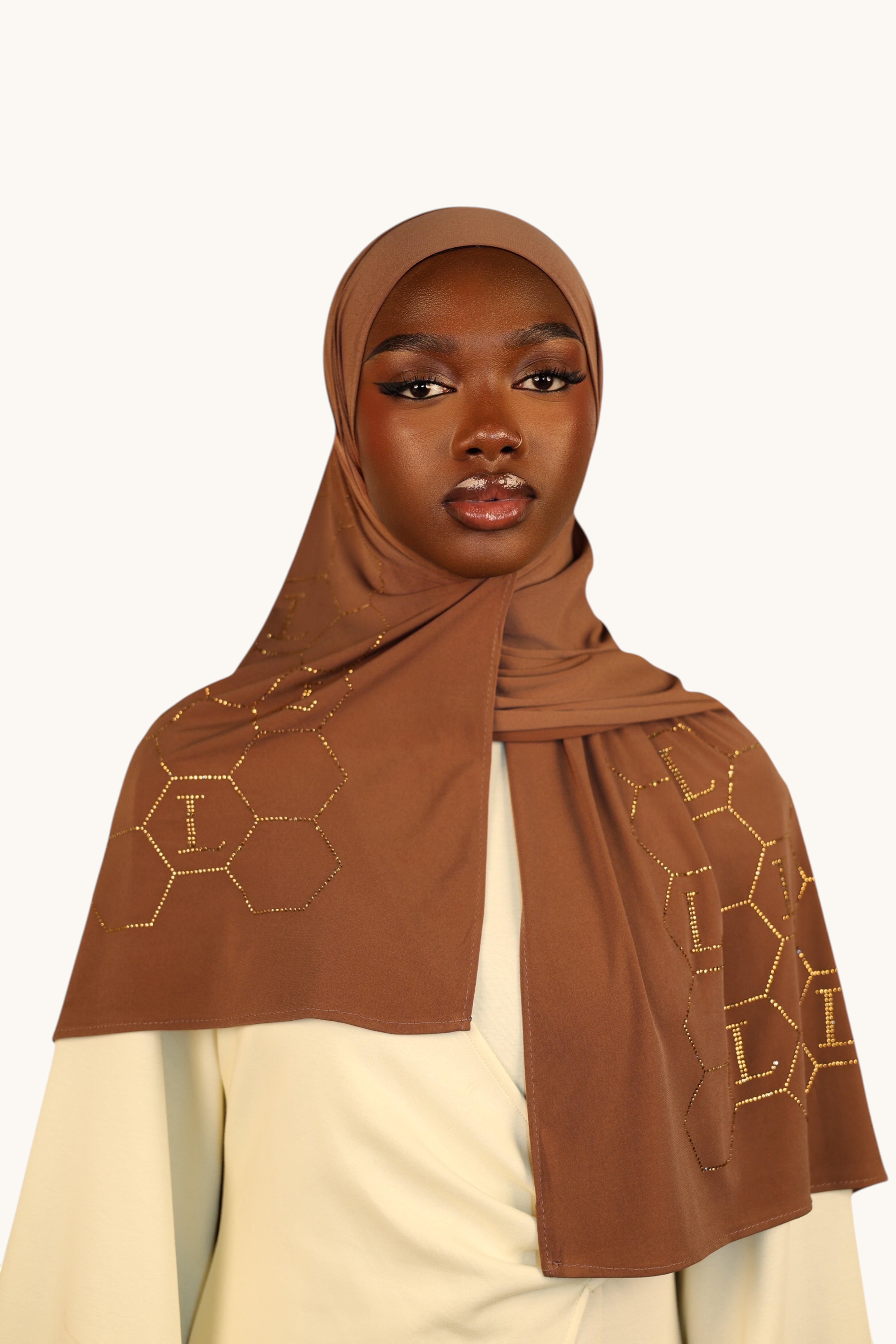 LOSYANA sahara brown premium jersey hijab featuring gold rhinestone honeycomb patterns and L logos on a model