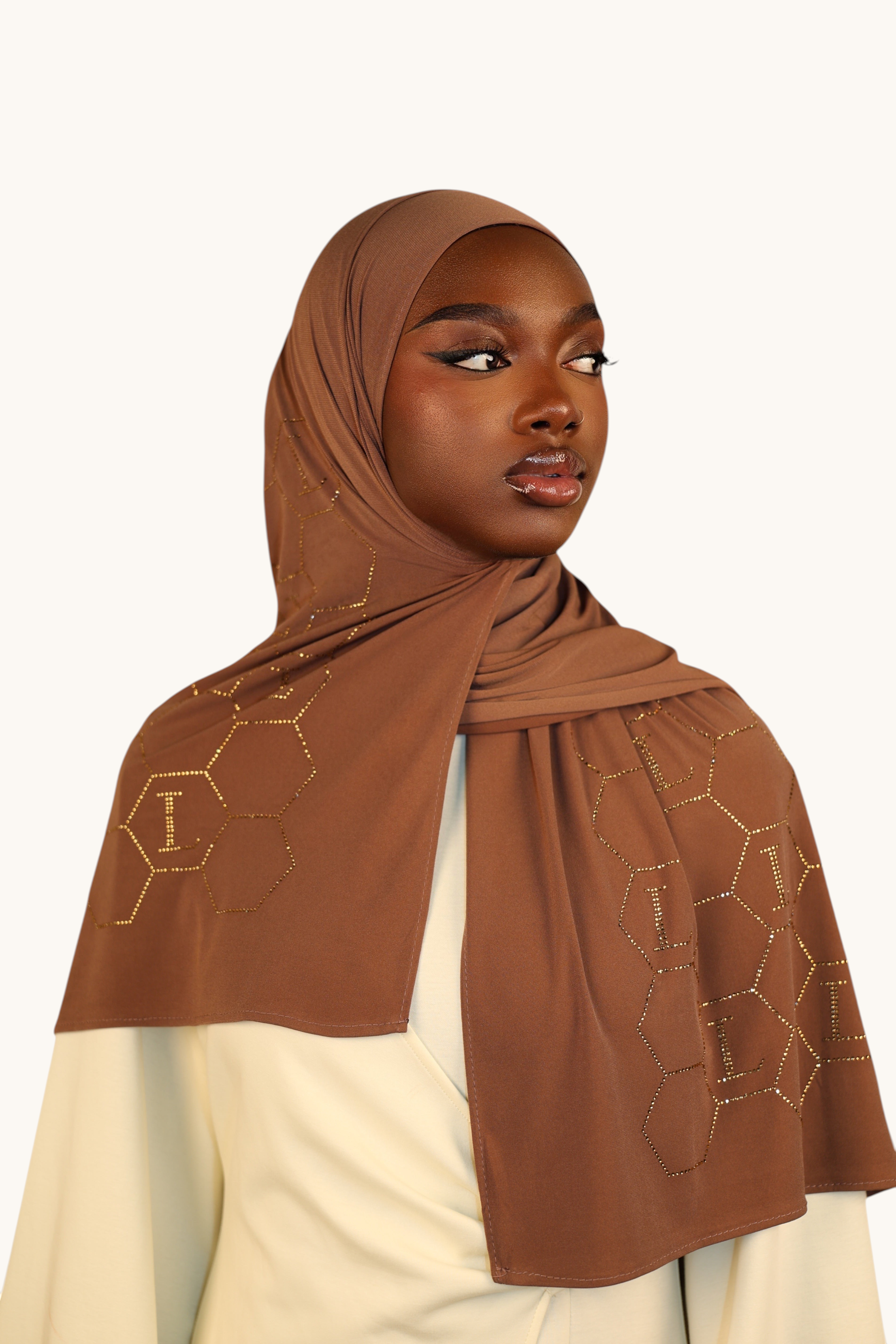 LOSYANA sahara brown premium jersey hijab with sparkling rhinestone L-logo and hexagonal pattern worn by a model