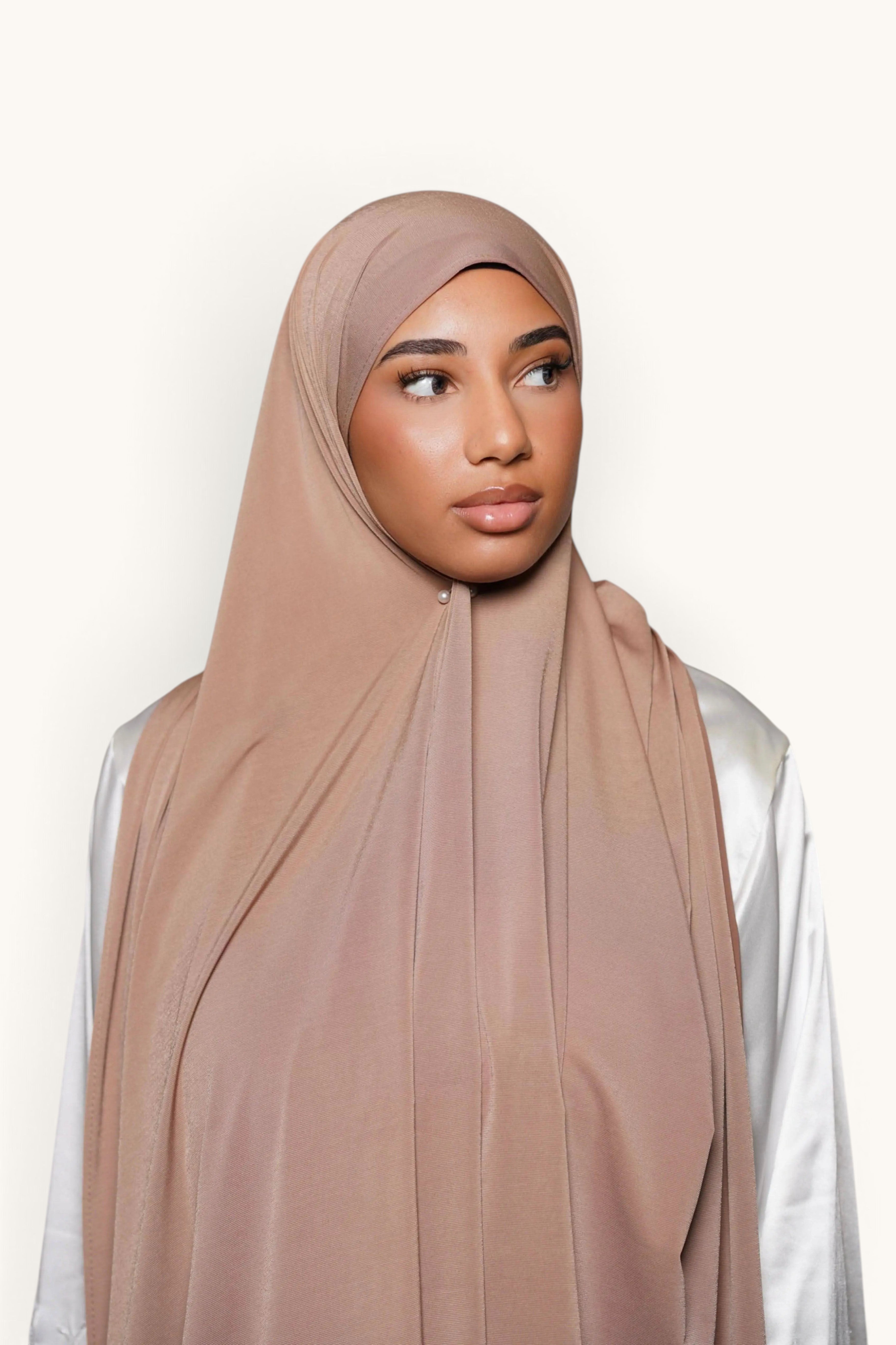Model wearing a sand-colored LOSYANA satin jersey hijab with a smooth, non-slip drape.
