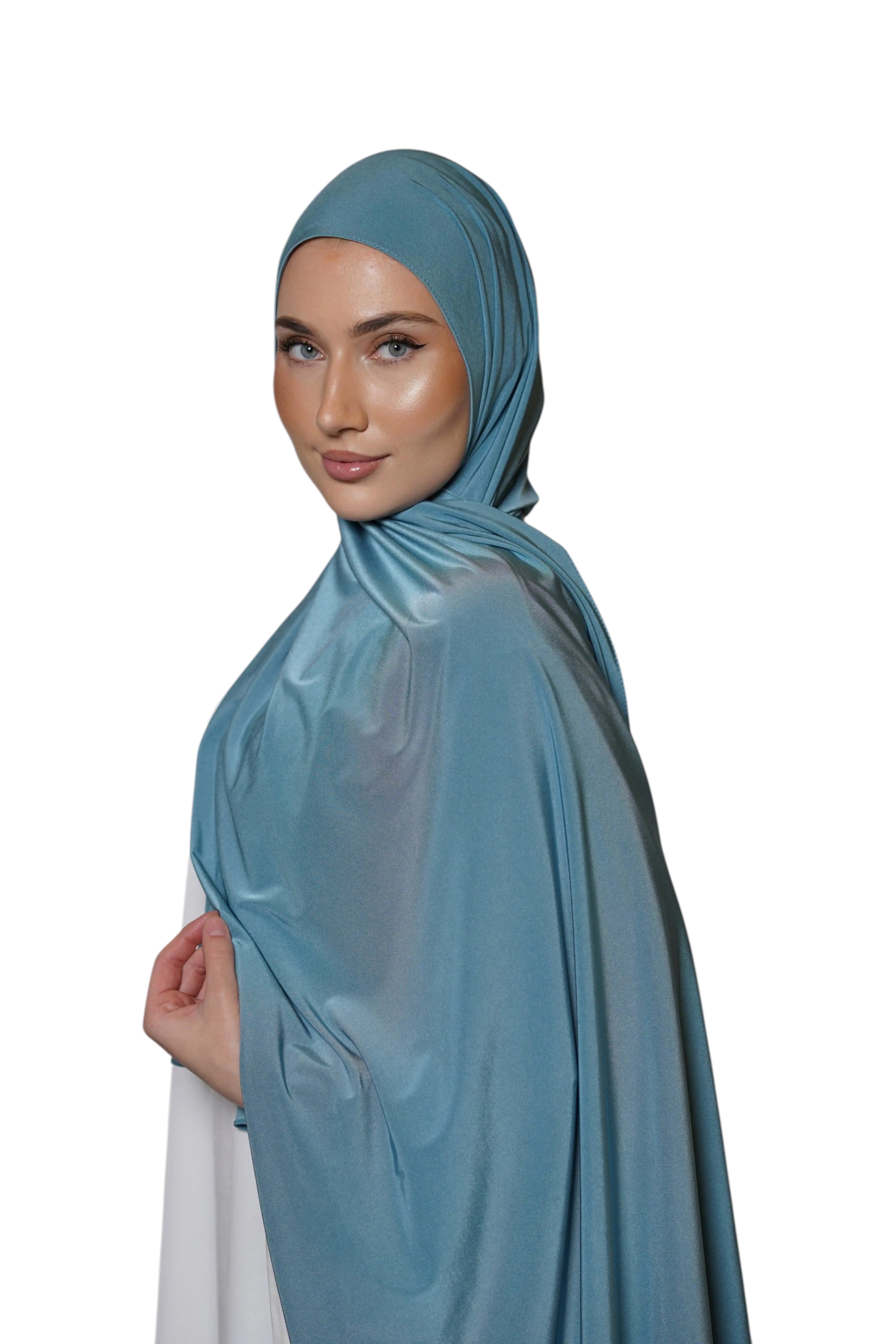 Model wearing a sky blue LOSYANA satin jersey hijab with a smooth, non-slip drape against a white background.