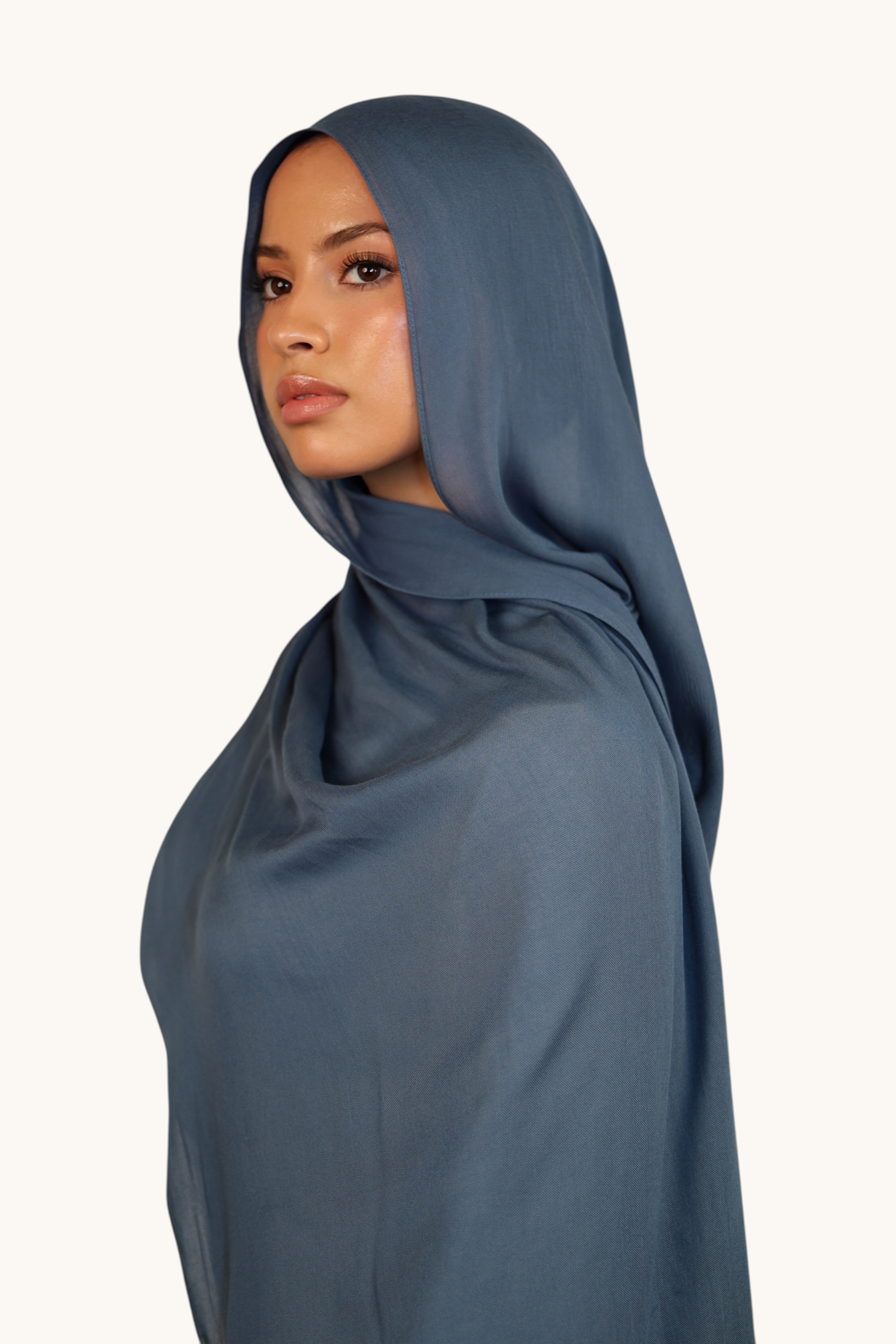 LOSYANA slate blue lightweight modal hijab worn by a model, featuring a soft, elegant, and semi-sheer draped fabric.