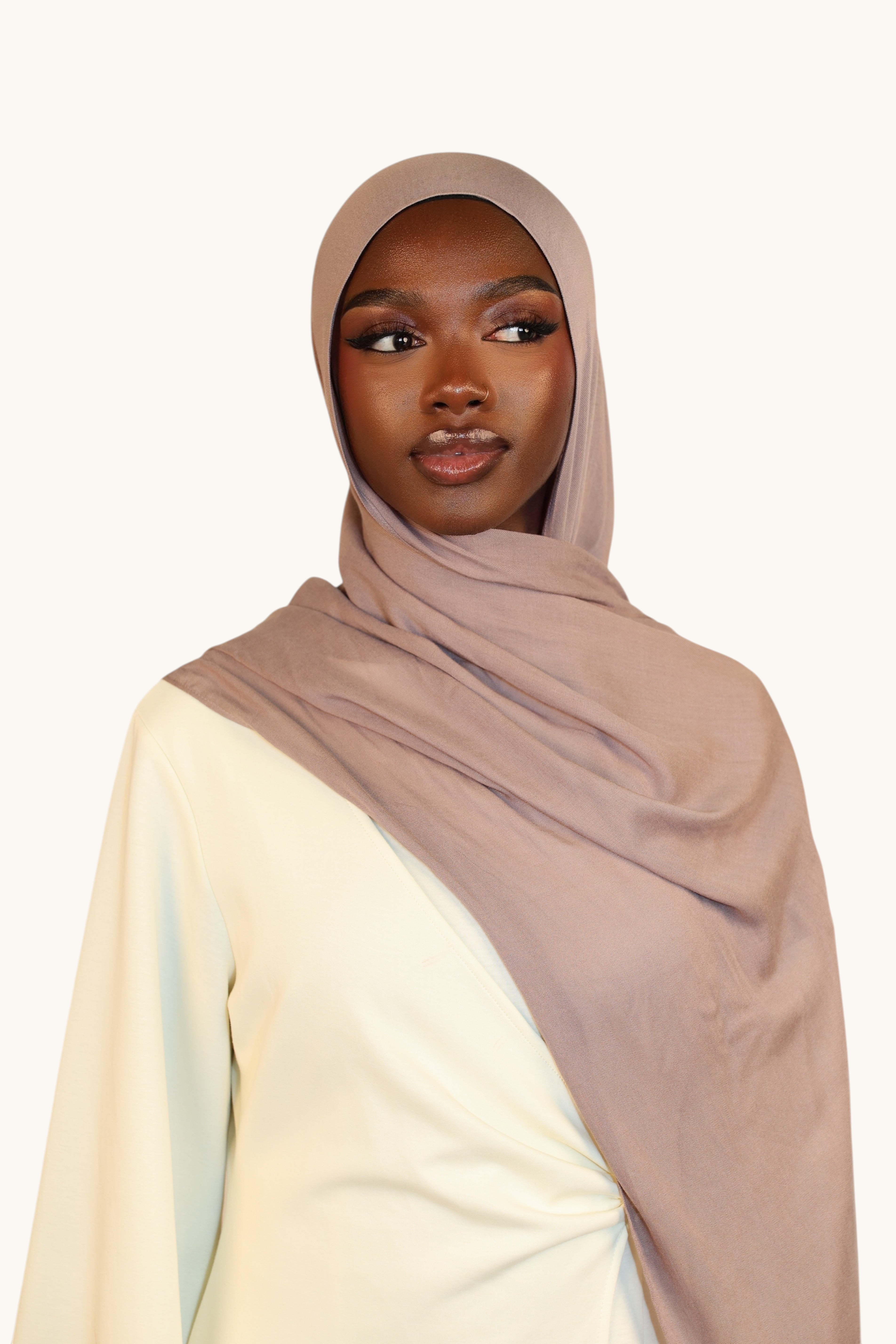 Model wearing a LOSYANA taupe gray lightweight modal hijab with a matching undercap, elegant and flowing drape.