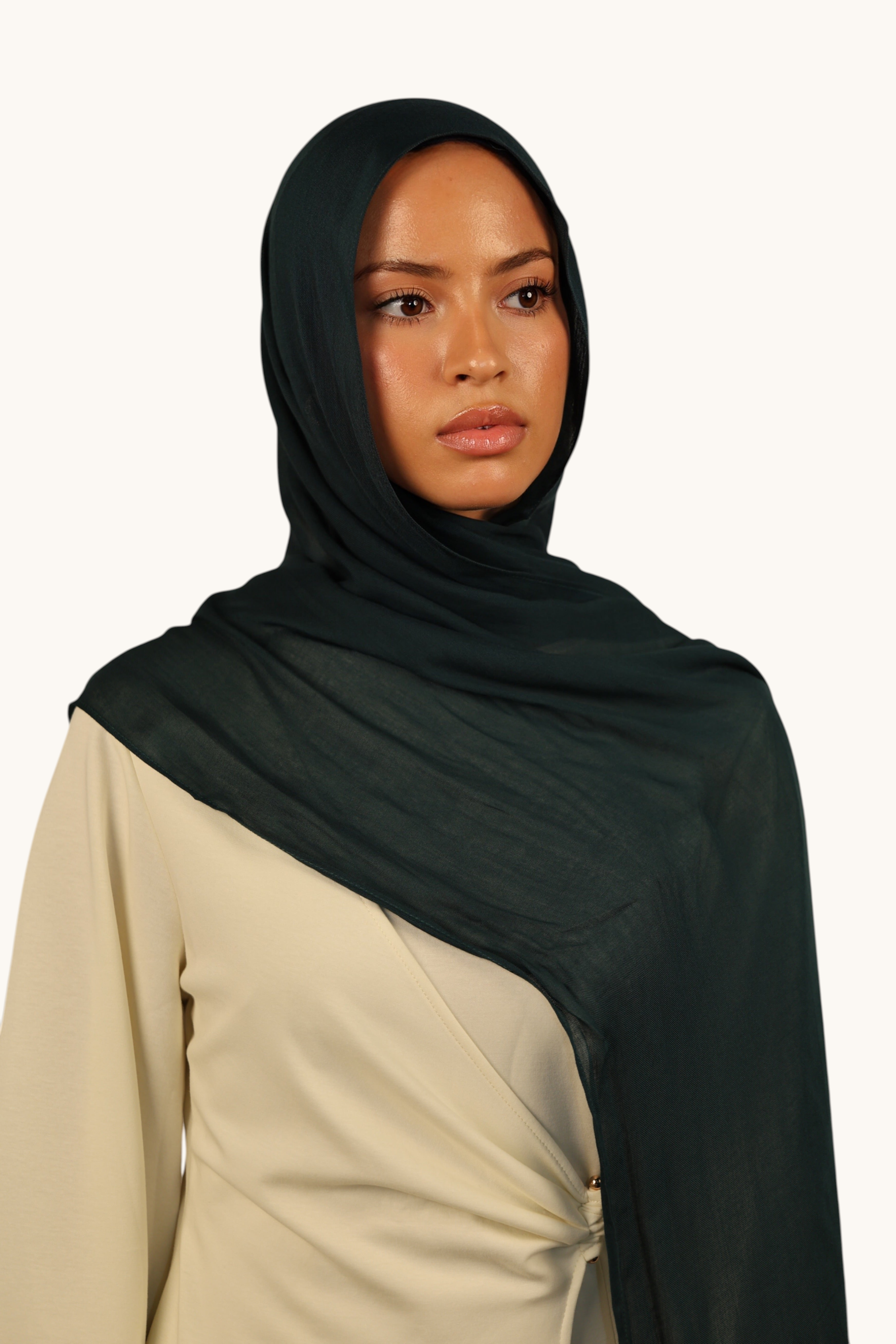 Model wearing a LOSYANA teal green lightweight modal hijab with a soft, elegant drape and subtle transparency.