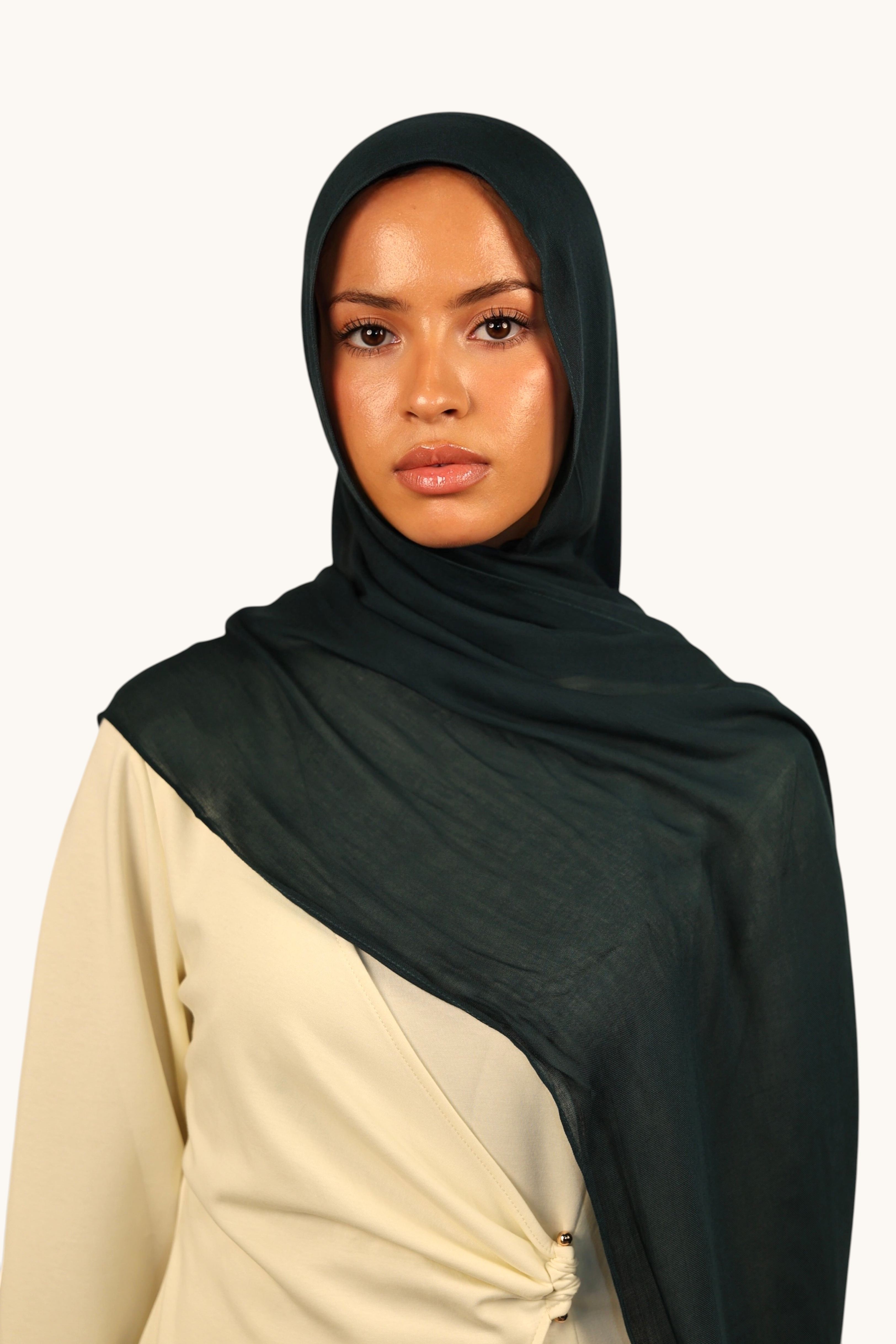 Model wearing a LOSYANA teal green lightweight modal hijab with a soft, elegant drape and subtle transparency.