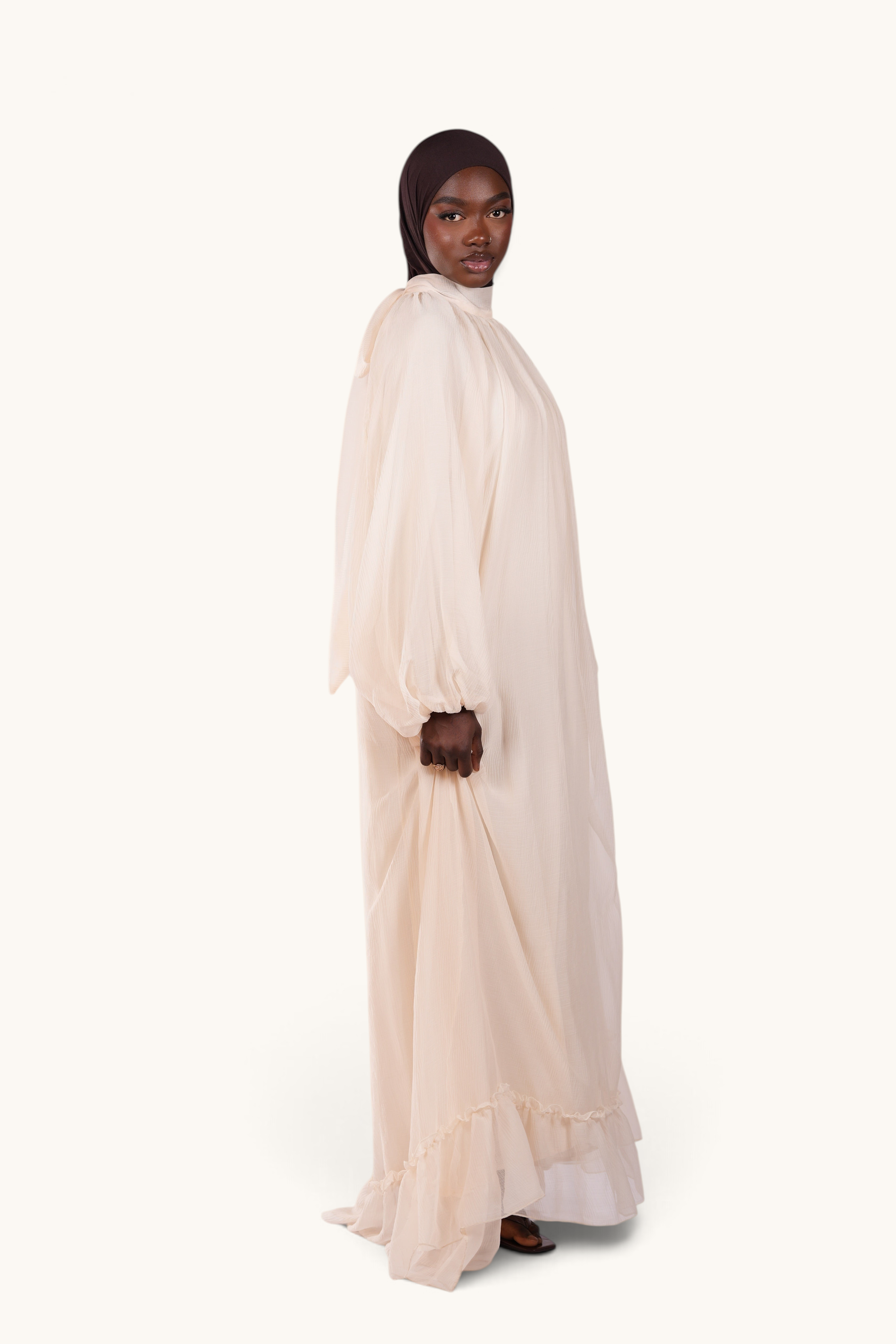 LOSYANA Tenerife ivory crepe maxi dress with balloon sleeves, high collar, and back bow detail on a model