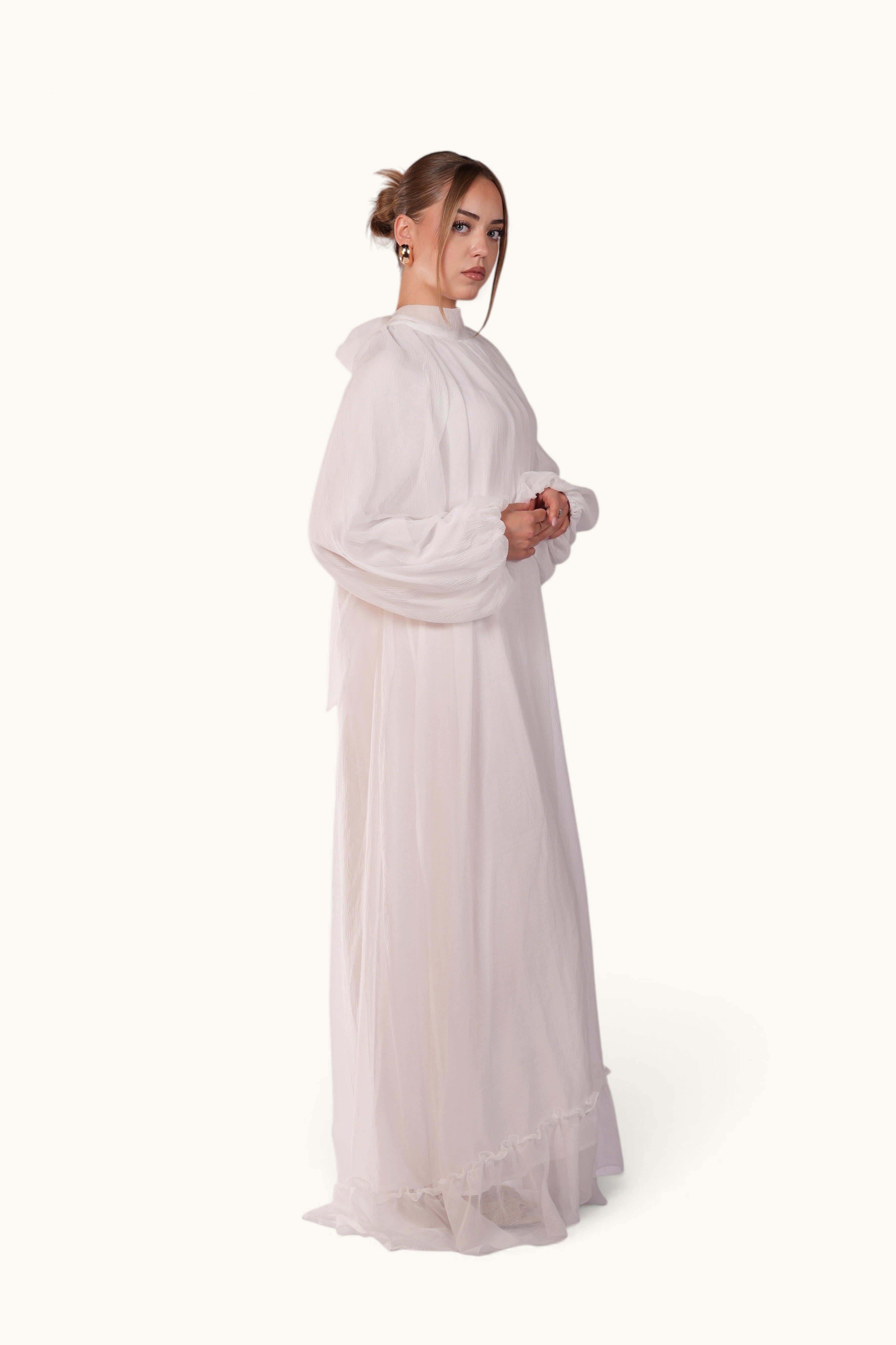 LOSYANA Tenerife white crepe maxi dress with high collar, balloon sleeves, and back bow detail on a model