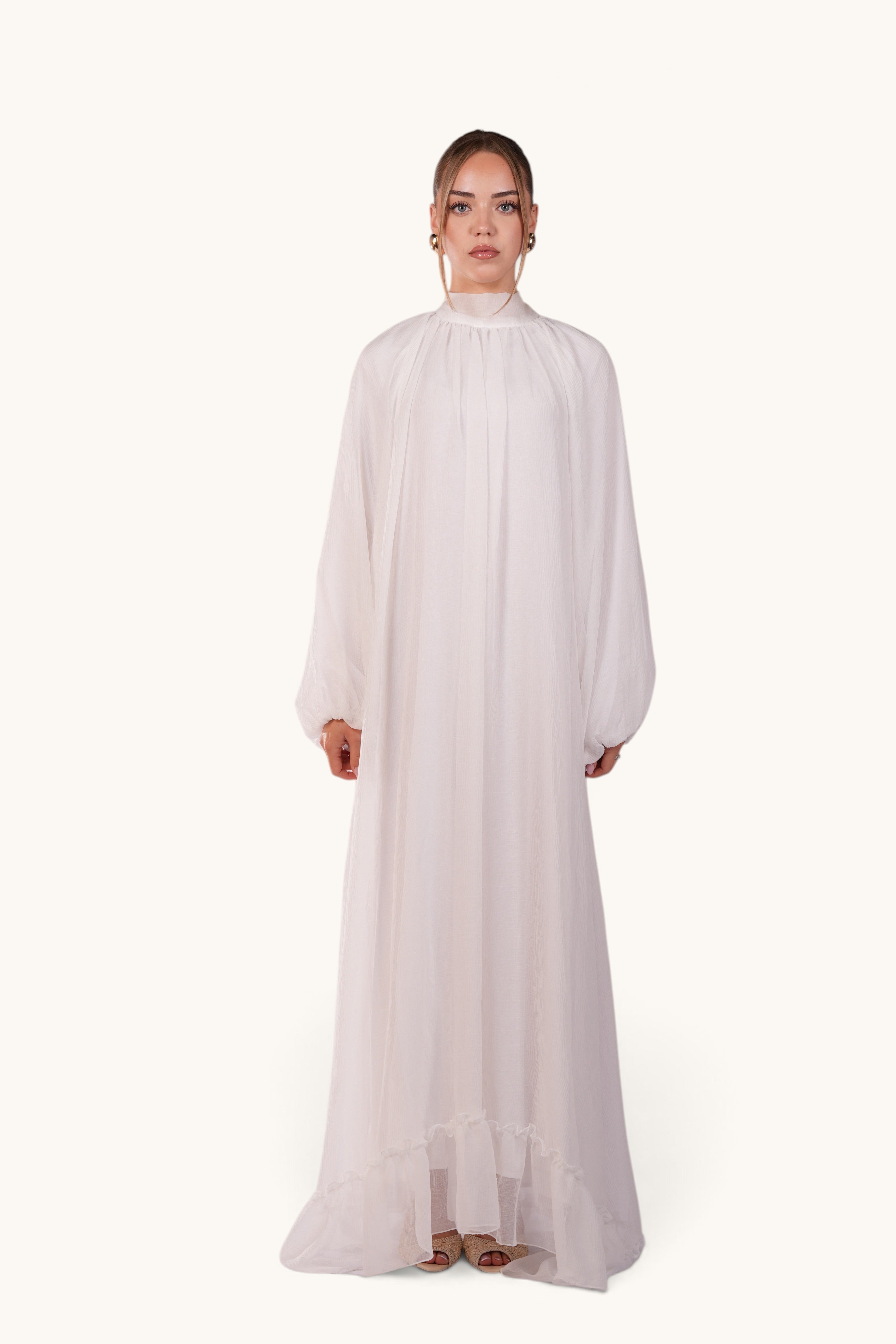 LOSYANA Tenerife white crepe maxi dress with high neck, balloon sleeves, and ruffled hem worn by a model