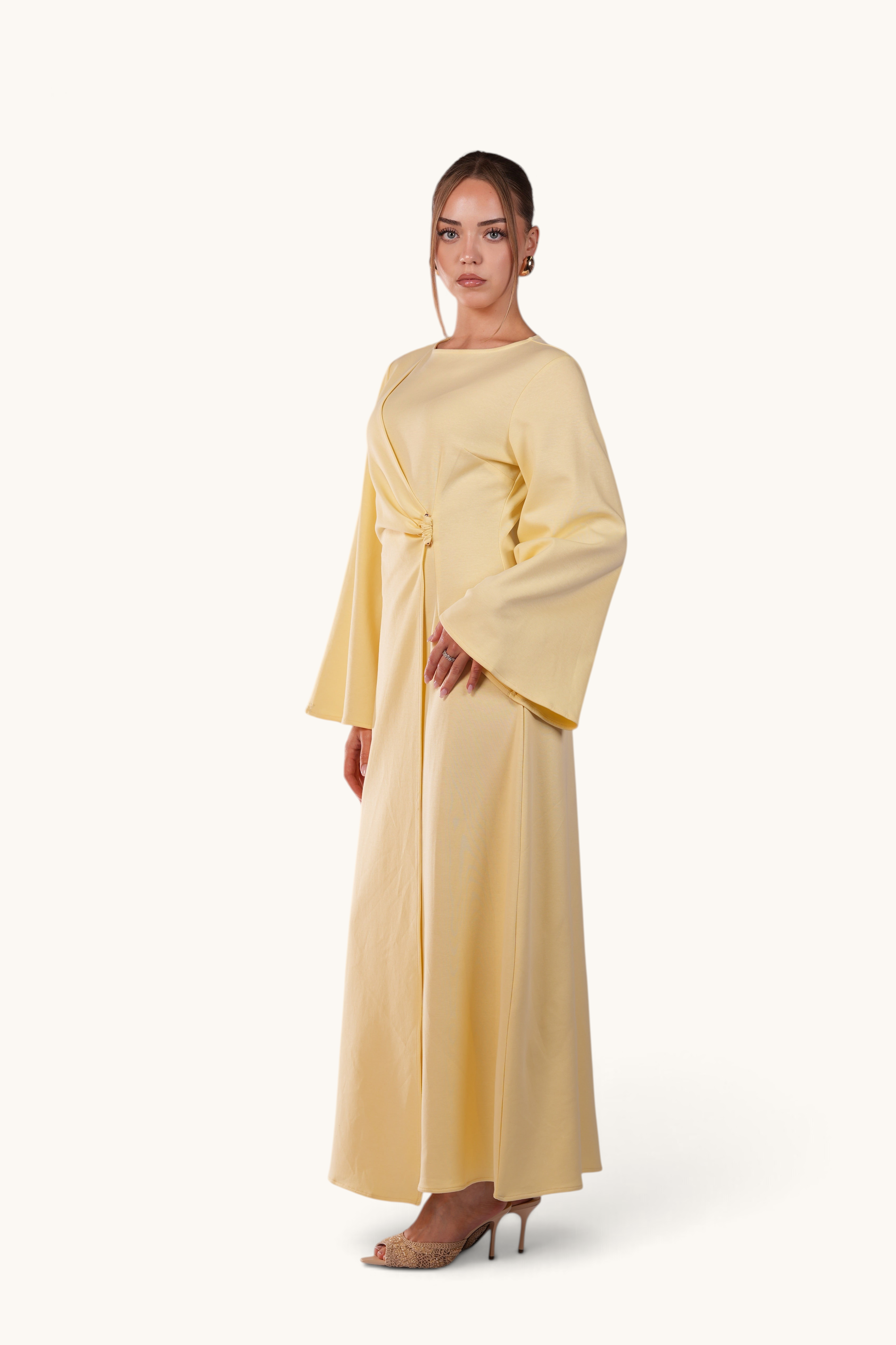 LOSYANA Valencia butter yellow maxi dress with trumpet sleeves and gold waist detail worn by a model