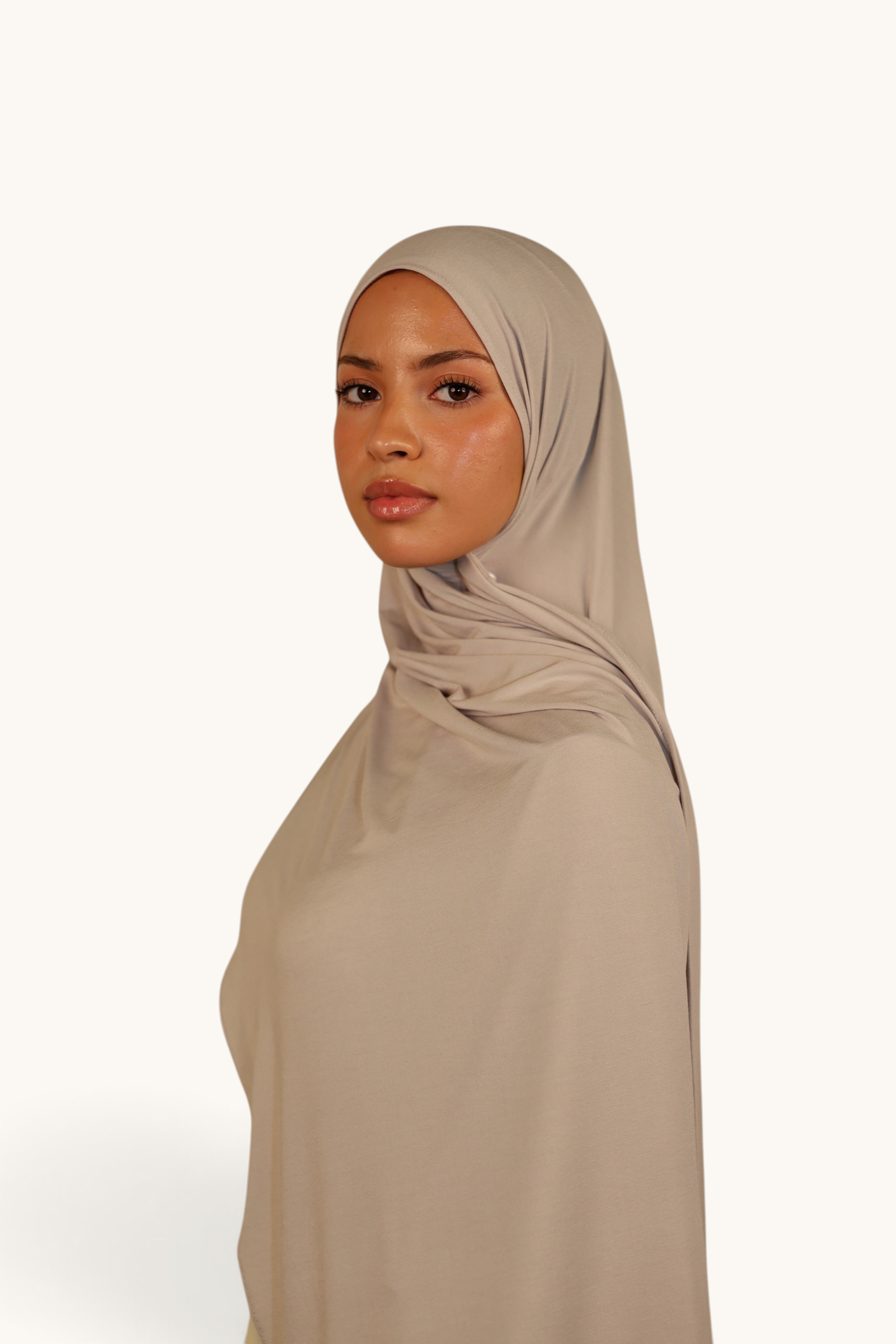 Model wearing a LOSYANA Vela Jersey hijab in ash beige, crafted from soft, breathable, lightweight fabric.