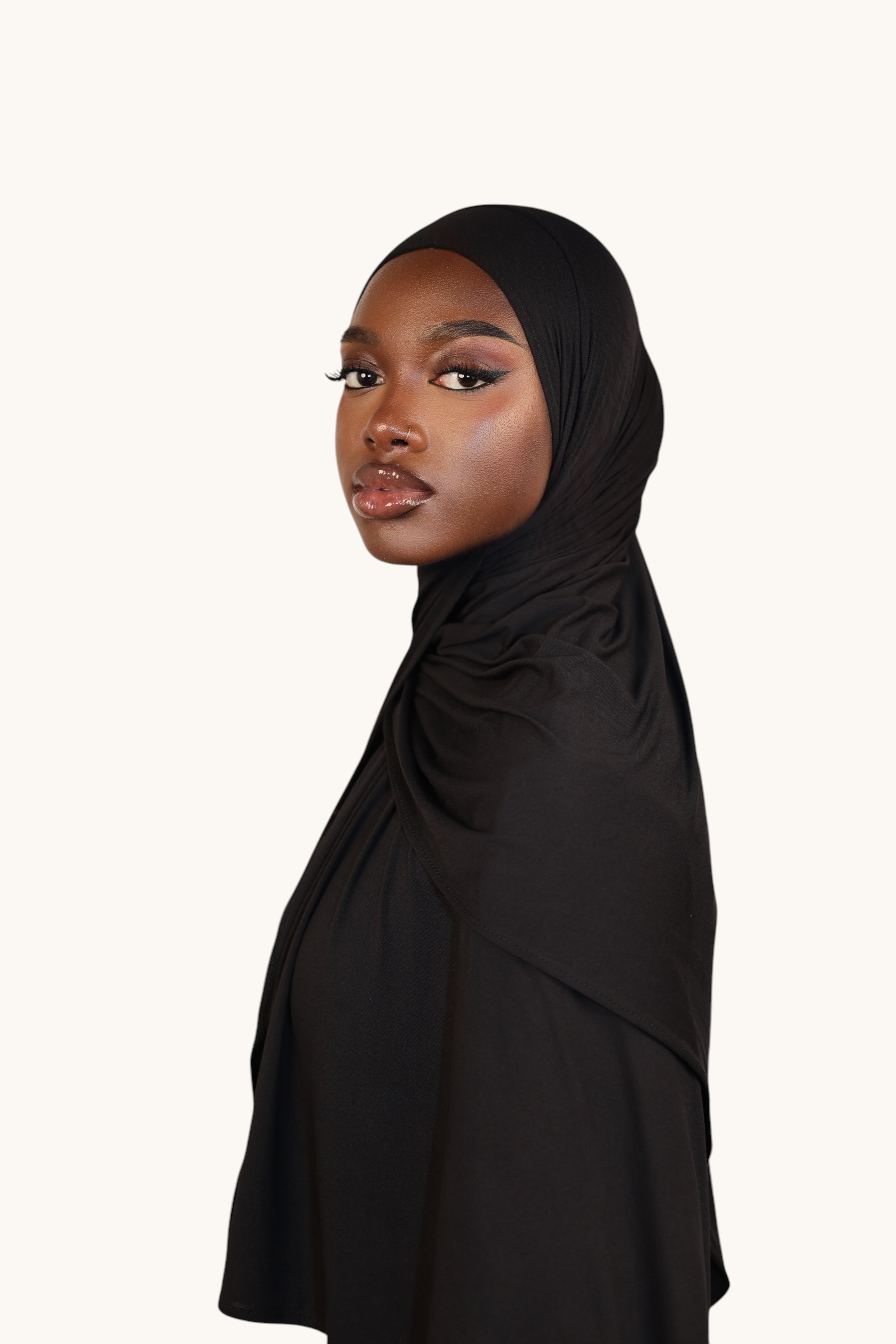 Model wearing a black LOSYANA Vela Jersey hijab made of soft, breathable fabric, styled elegantly.