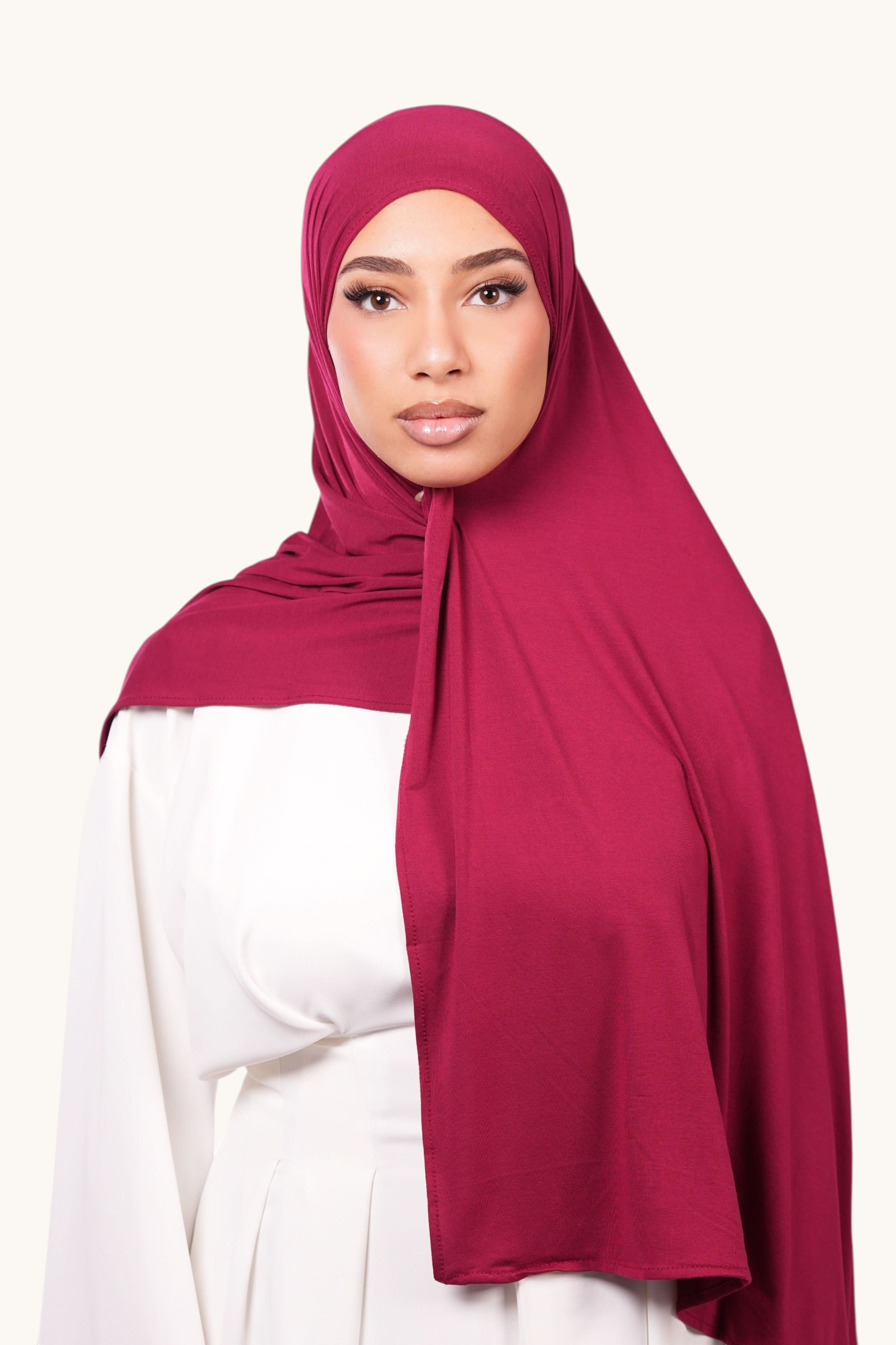 Model wearing a bordeaux LOSYANA Vela Jersey hijab made of soft, breathable fabric, styled over a white top.