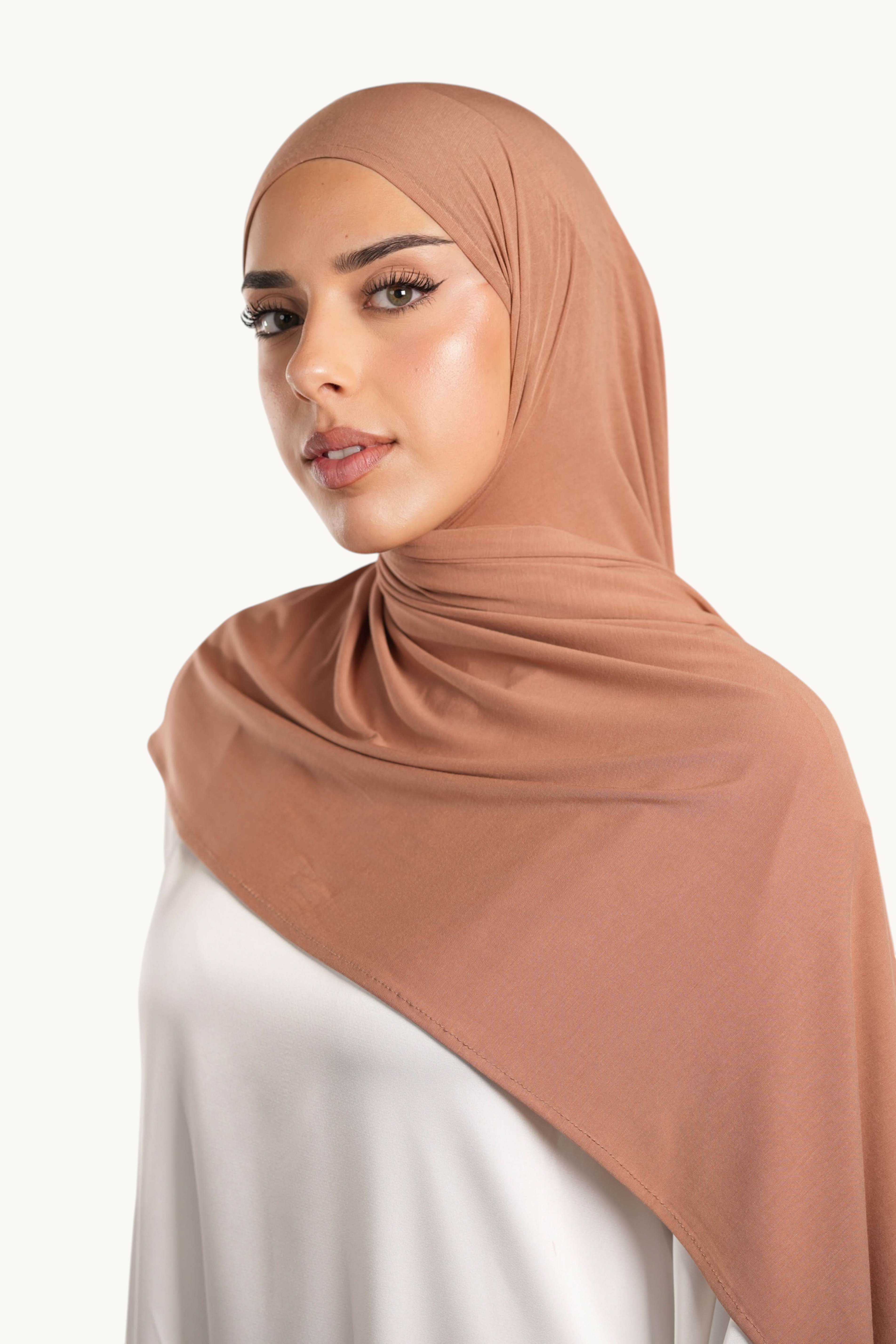 Model wearing a caramel LOSYANA Vela Jersey, a soft and lightweight breathable hijab scarf.