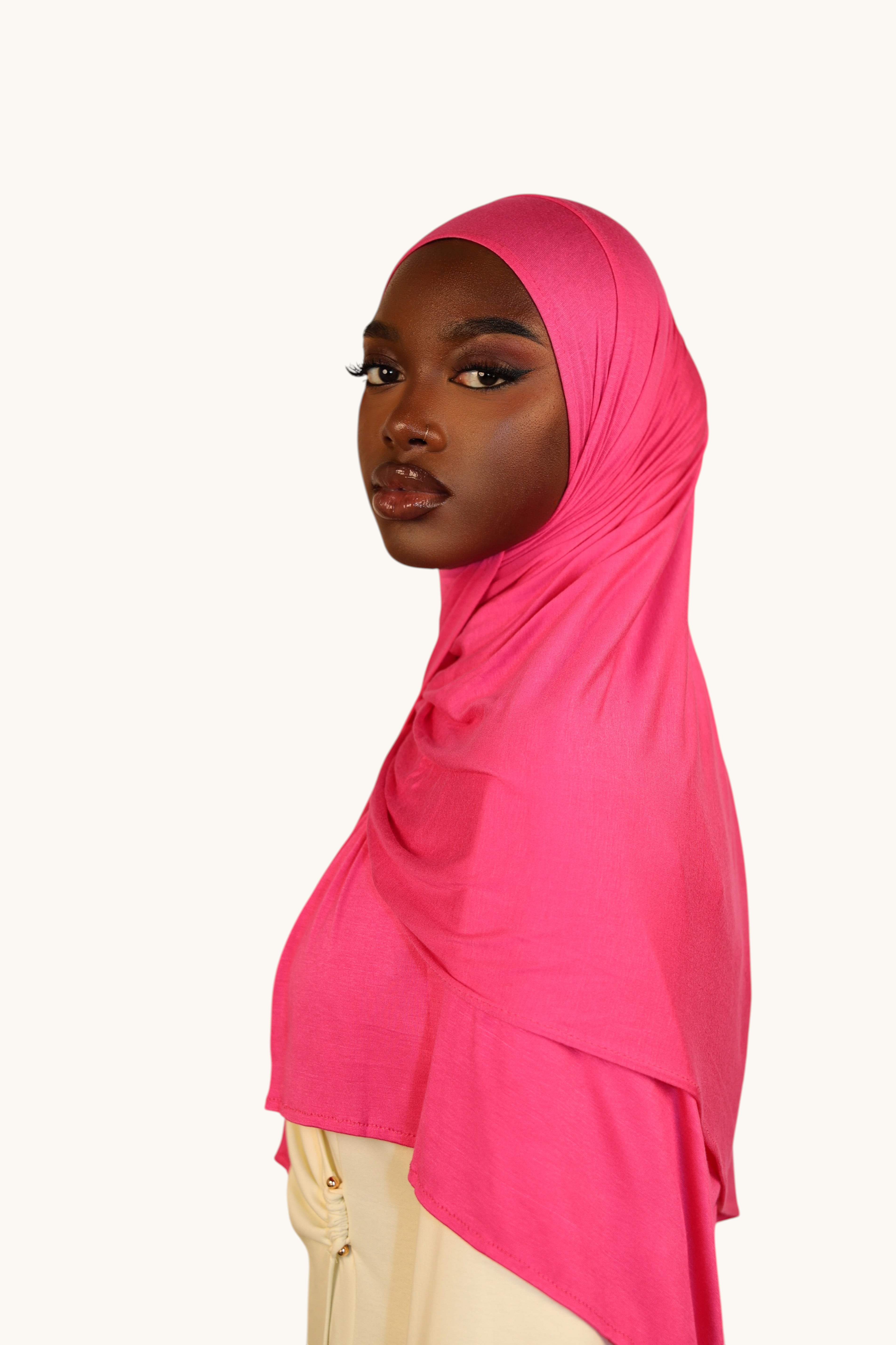 Model wearing a vibrant hot pink LOSYANA Vela Jersey hijab made of soft, breathable fabric against a neutral background