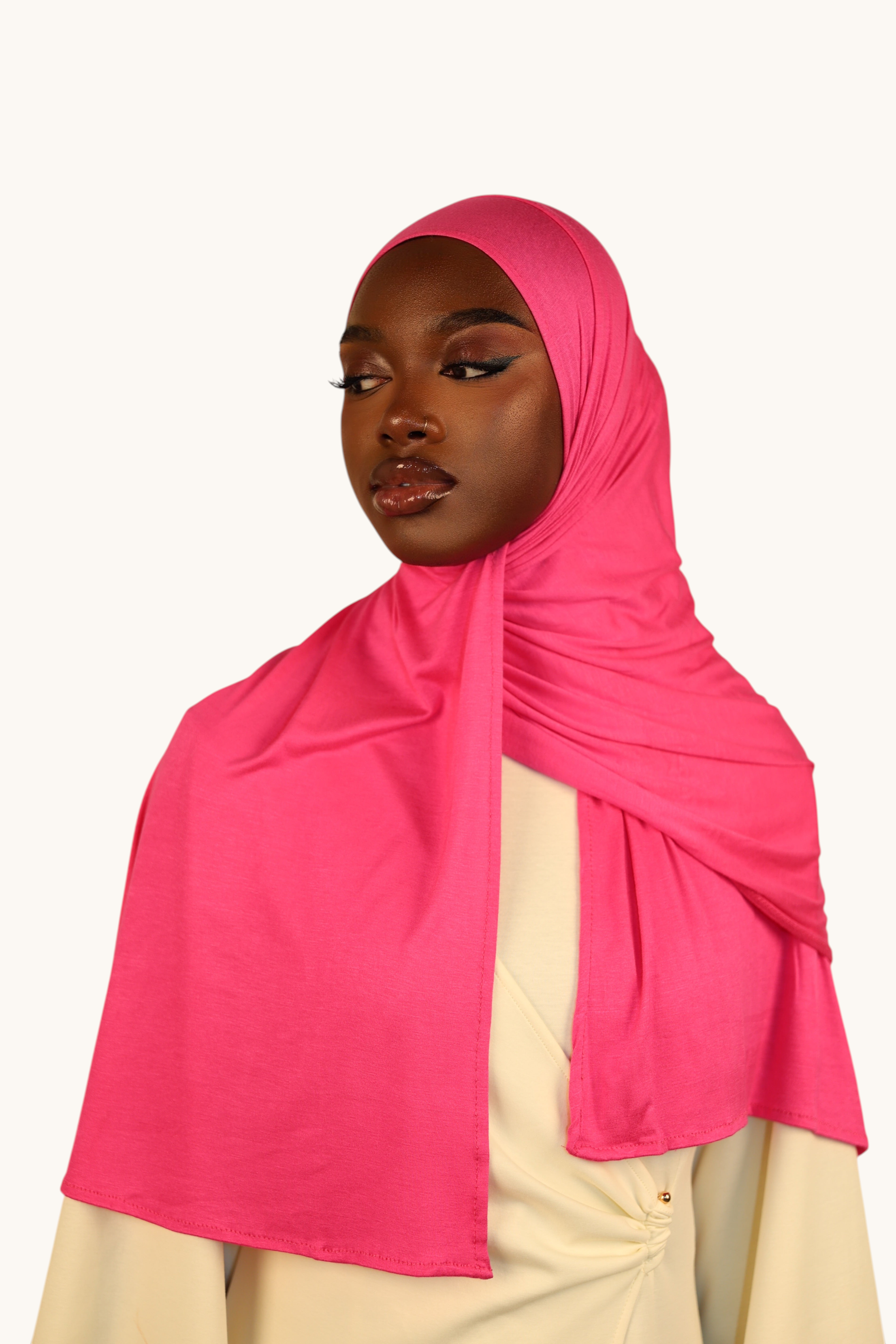 Model wearing a hot pink LOSYANA Vela Jersey hijab made of soft, breathable fabric against a neutral background.