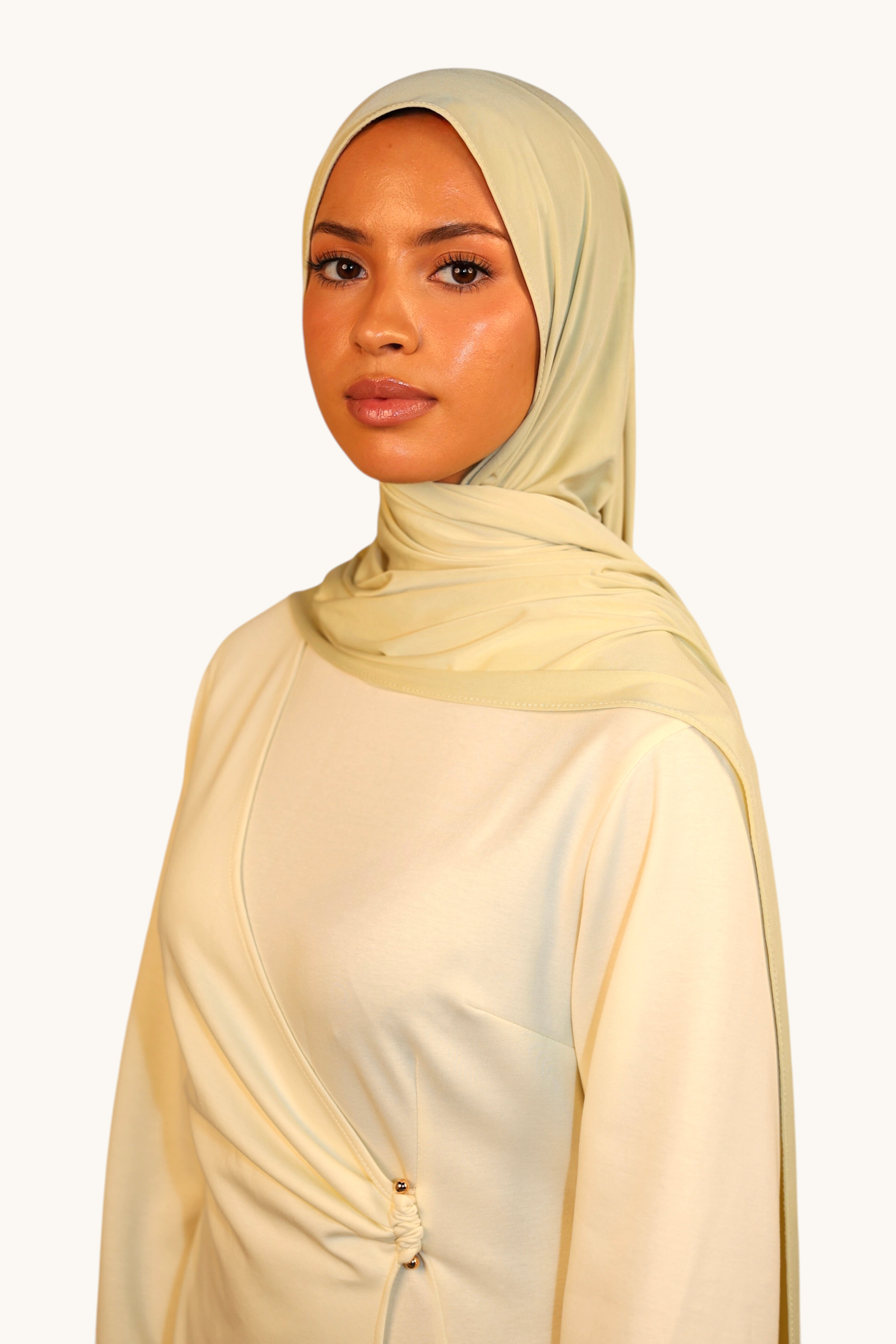 Model wearing a light lime LOSYANA Vela Jersey hijab made of soft, breathable fabric in a studio setting.