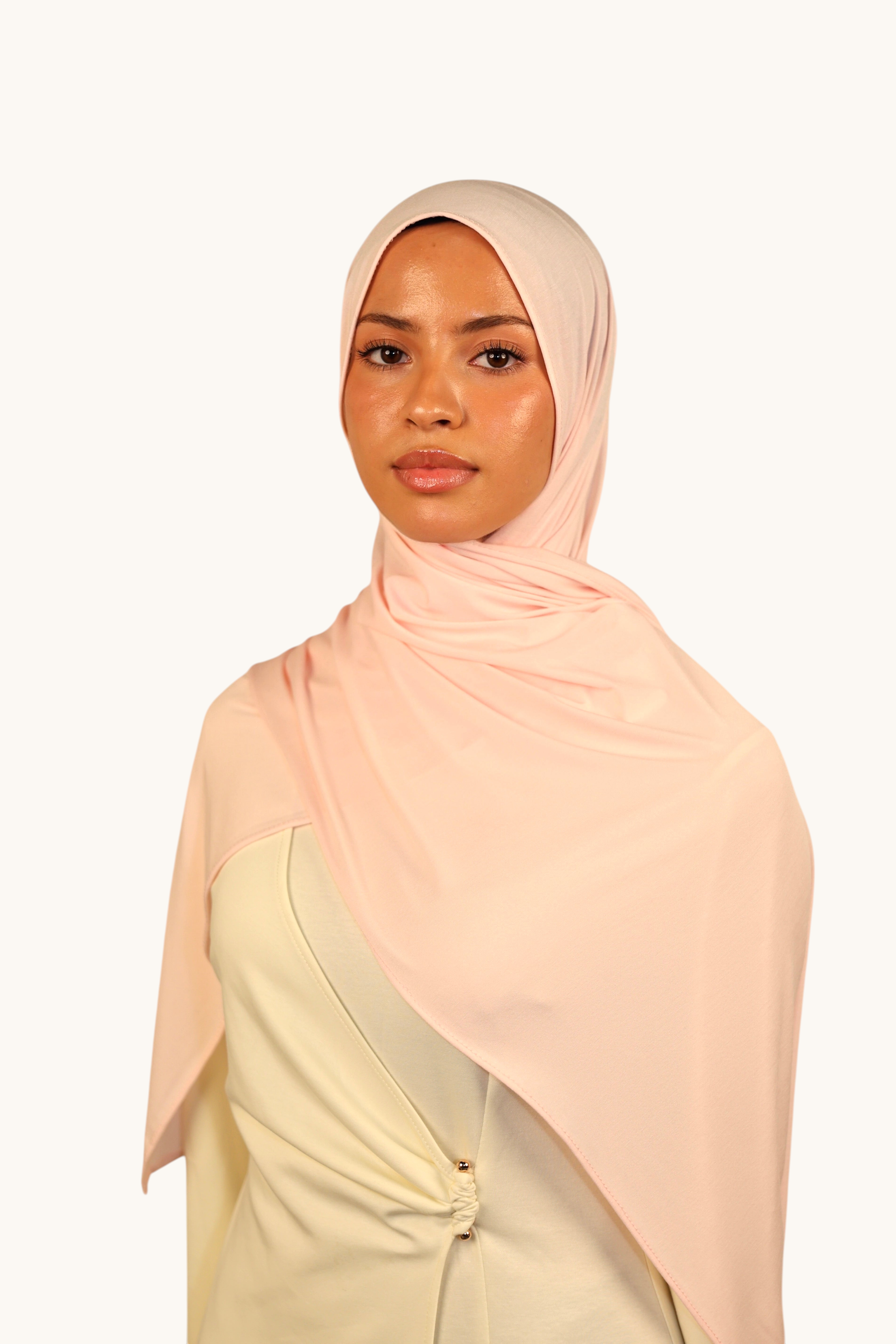 Model wearing a light rose LOSYANA Vela Jersey hijab made of soft, breathable fabric, styled elegantly.