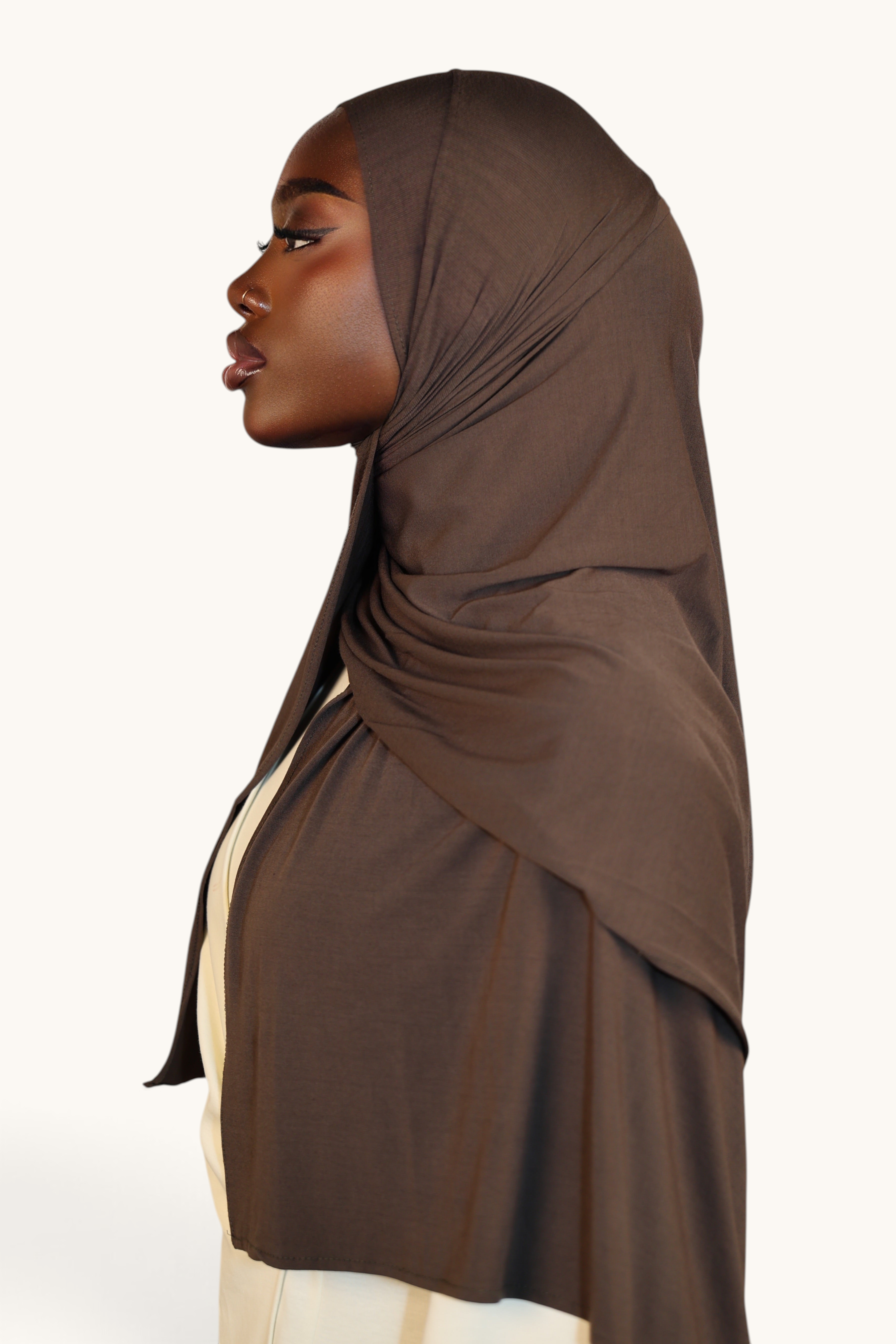 LOSYANA Vela Jersey in Nougatbraun, getragen als elegantes Hijab von einem Model im Seitenprofil