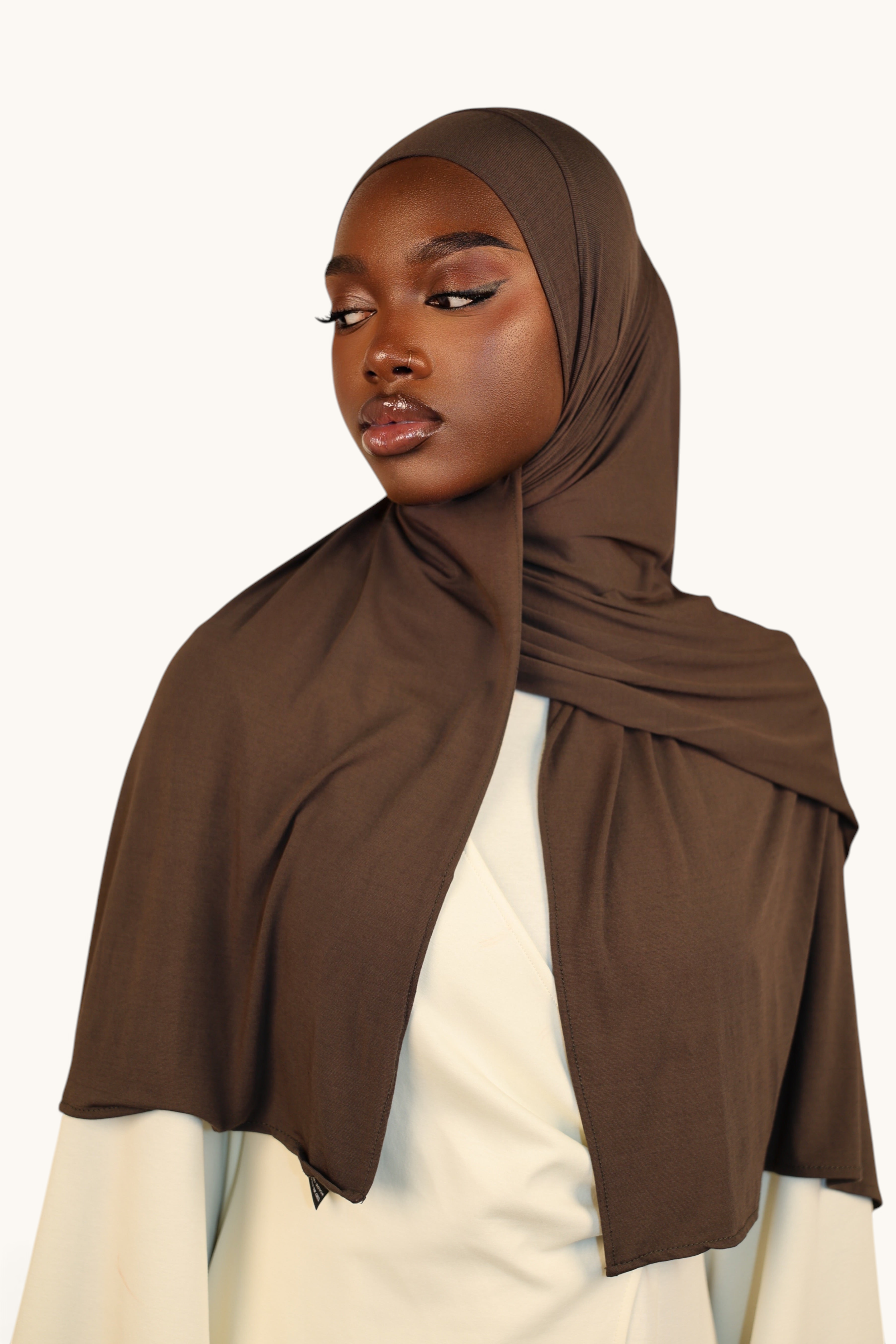 LOSYANA Vela Jersey in Nougatbraun, ein weiches, atmungsaktives Tuch getragen als eleganter Hijab von einem Model.