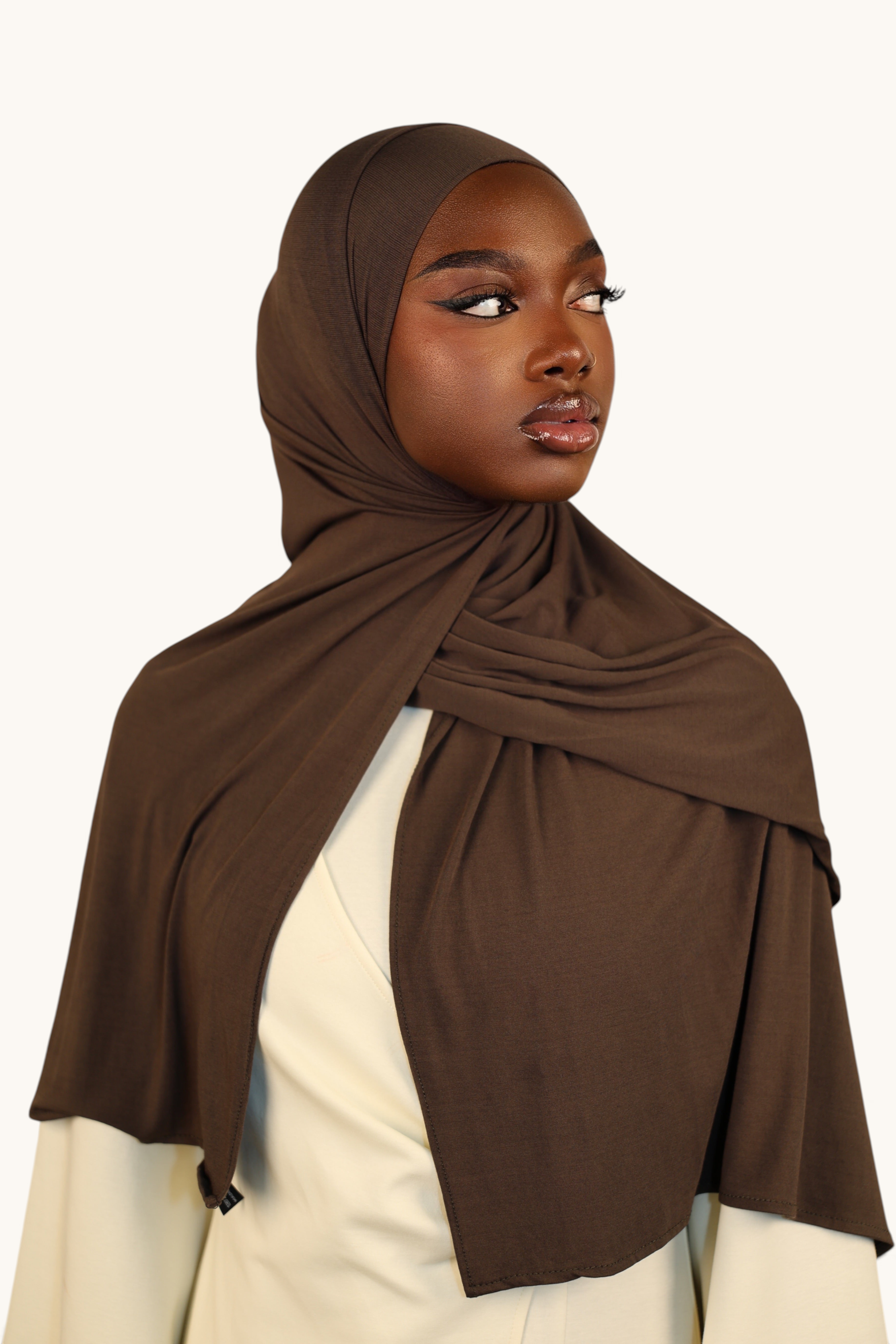 Model trägt ein nougatfarbenes LOSYANA Vela Jersey Kopftuch aus weichem, atmungsaktivem Stoff in eleganter Wickeloptik