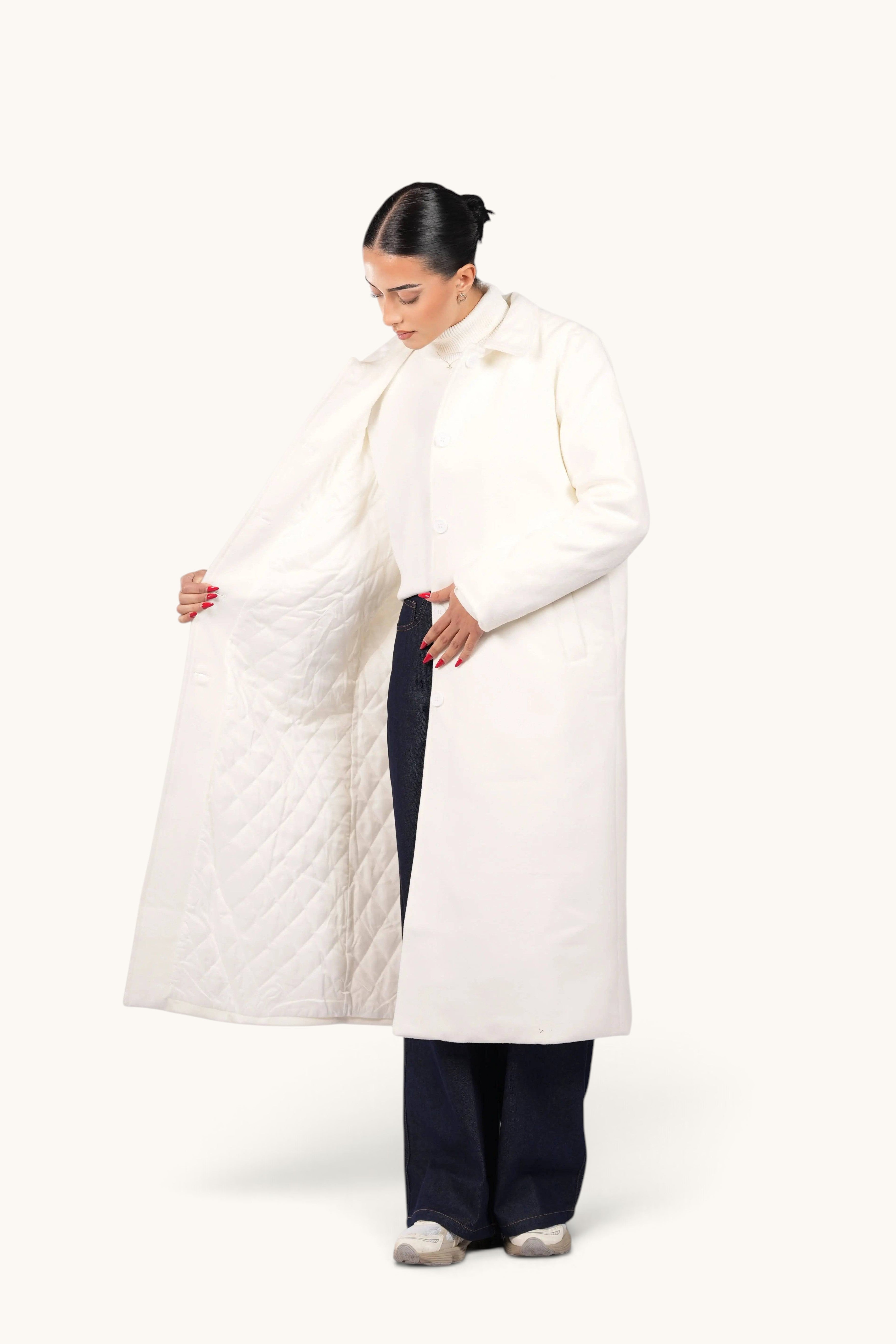 Model wearing a white LOSYANA Vienna coat with a quilted interior lining, styled with dark jeans and sneakers.