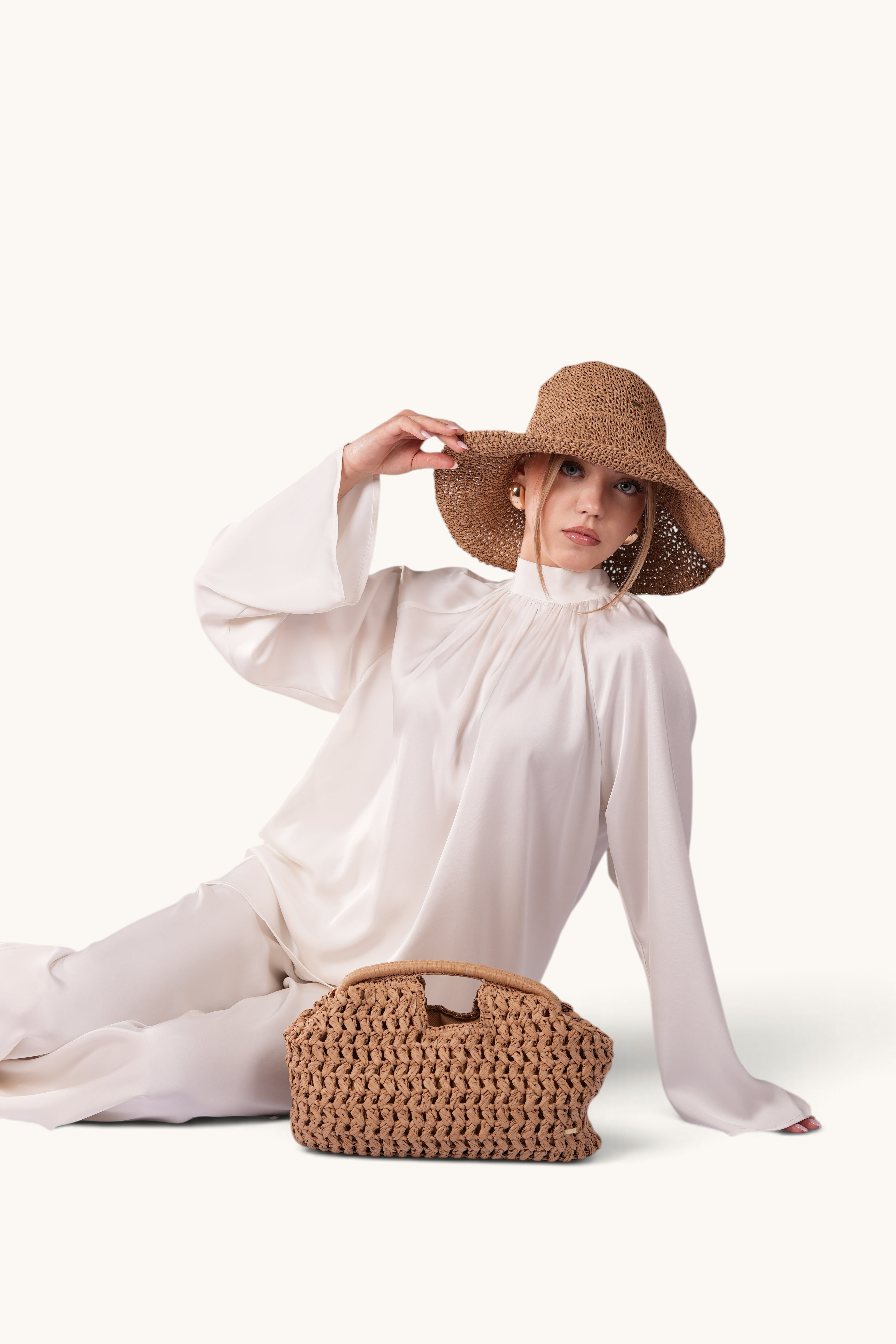 LOSYANA walnut woven straw handbag with a model wearing a matching straw hat and white satin outfit