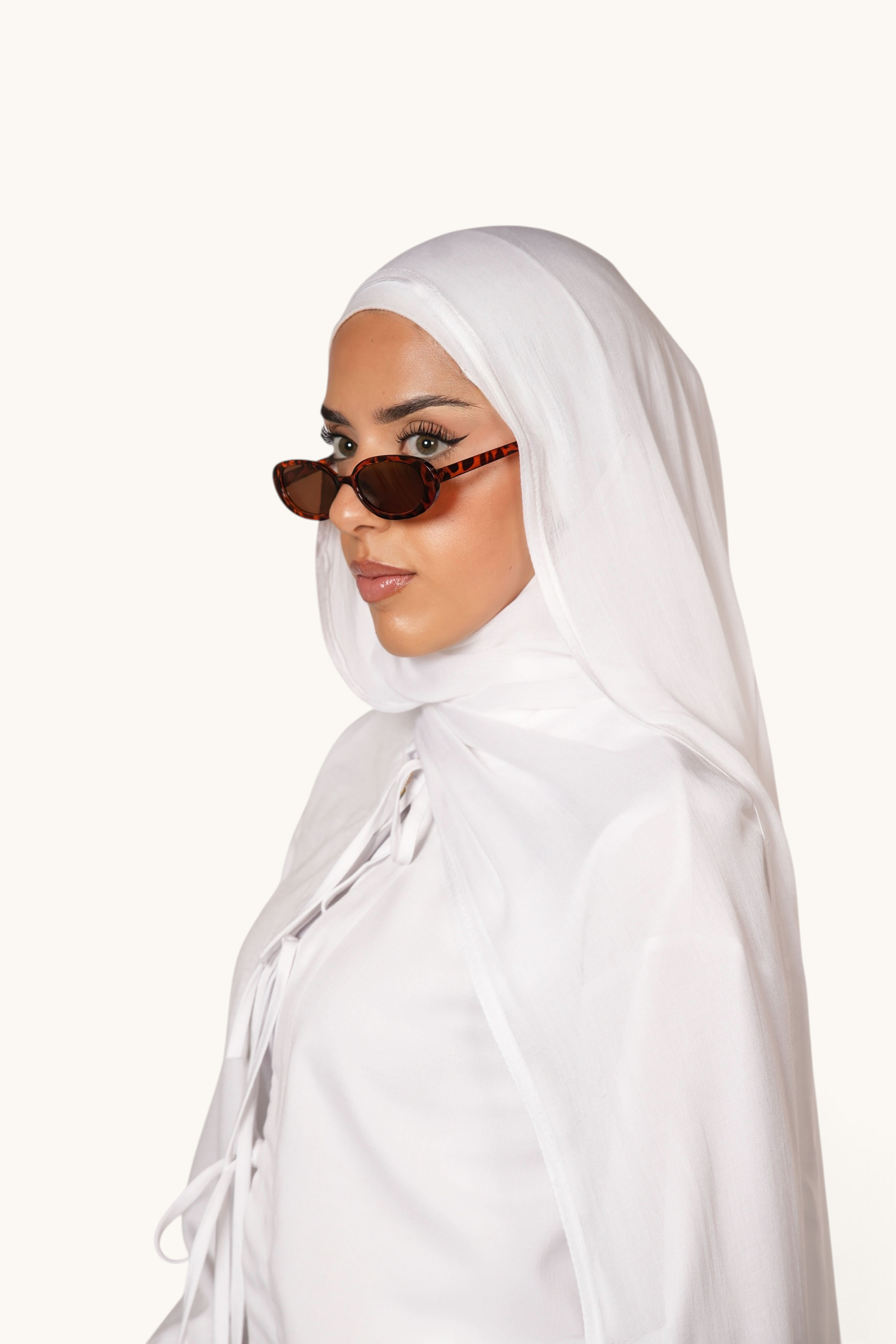 LOSYANA white lightweight modal hijab worn by a model with brown tortoiseshell sunglasses