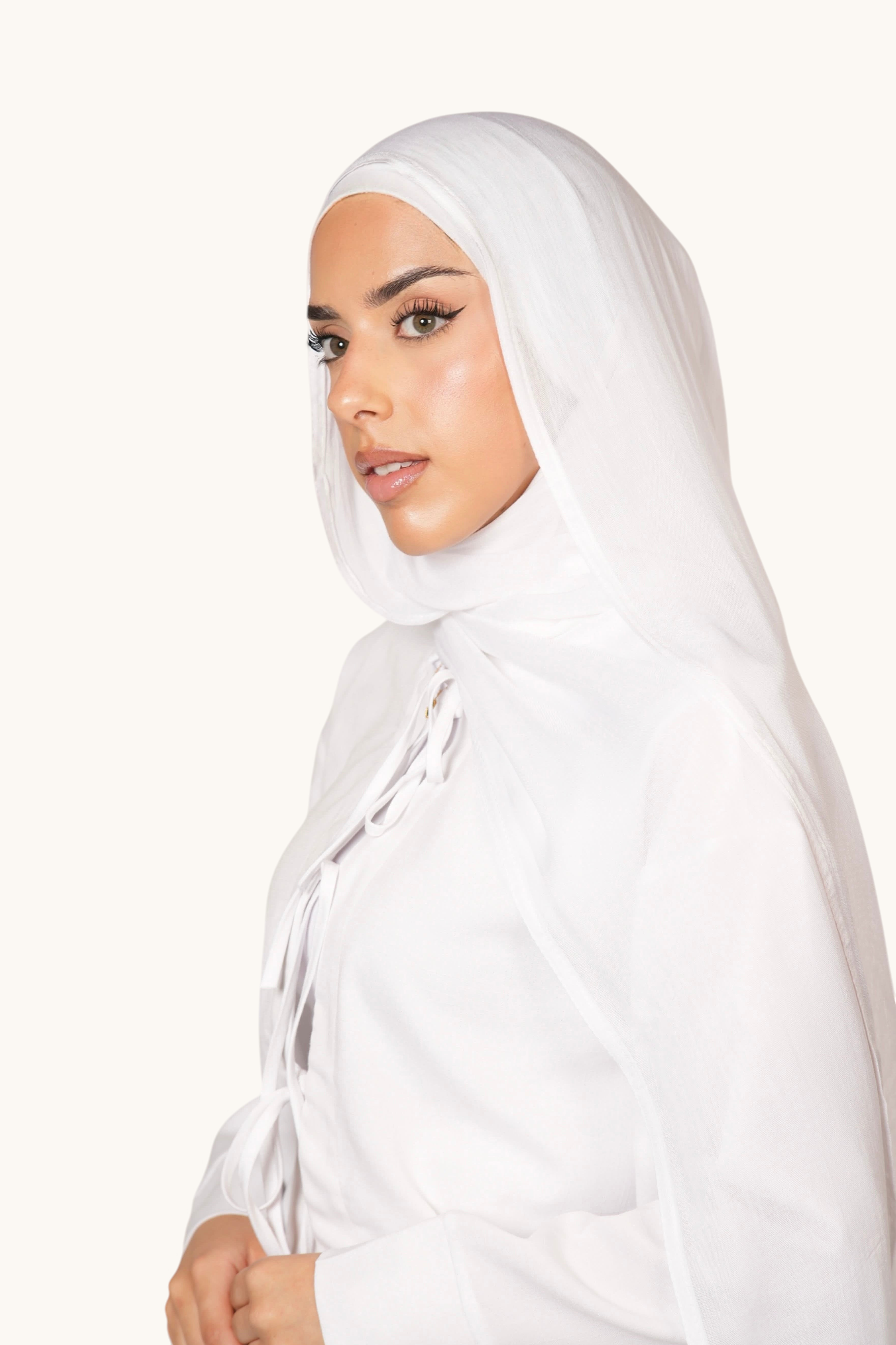 Model wearing a white LOSYANA lightweight modal hijab with a matching undercap, featuring a soft, elegant drape.